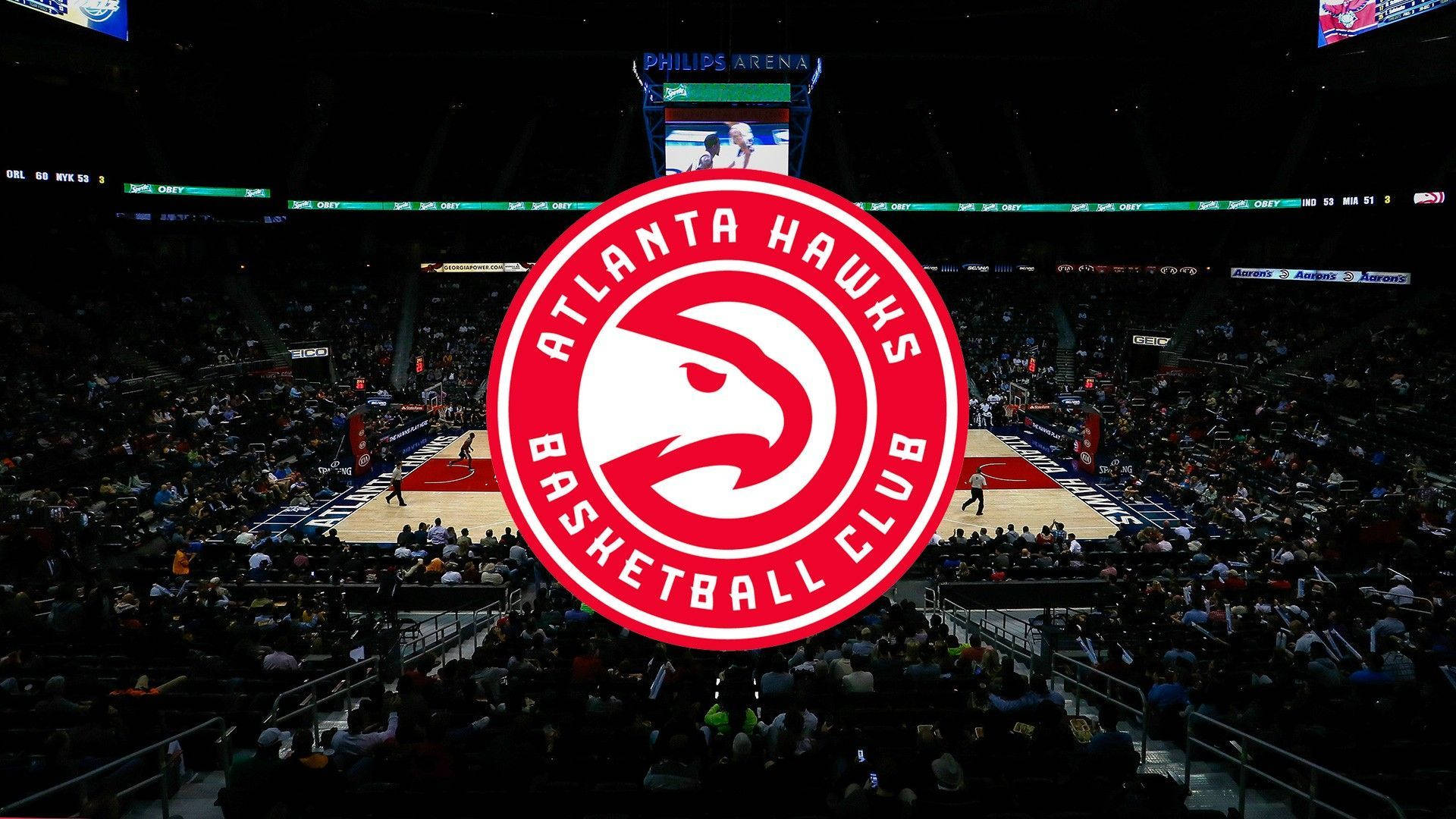 Atlanta Hawks 隊徽於籃球場 壁紙 — 亞特蘭大老鷹隊籃球場在明亮的場館燈光下，比賽期間擠滿了球迷。
