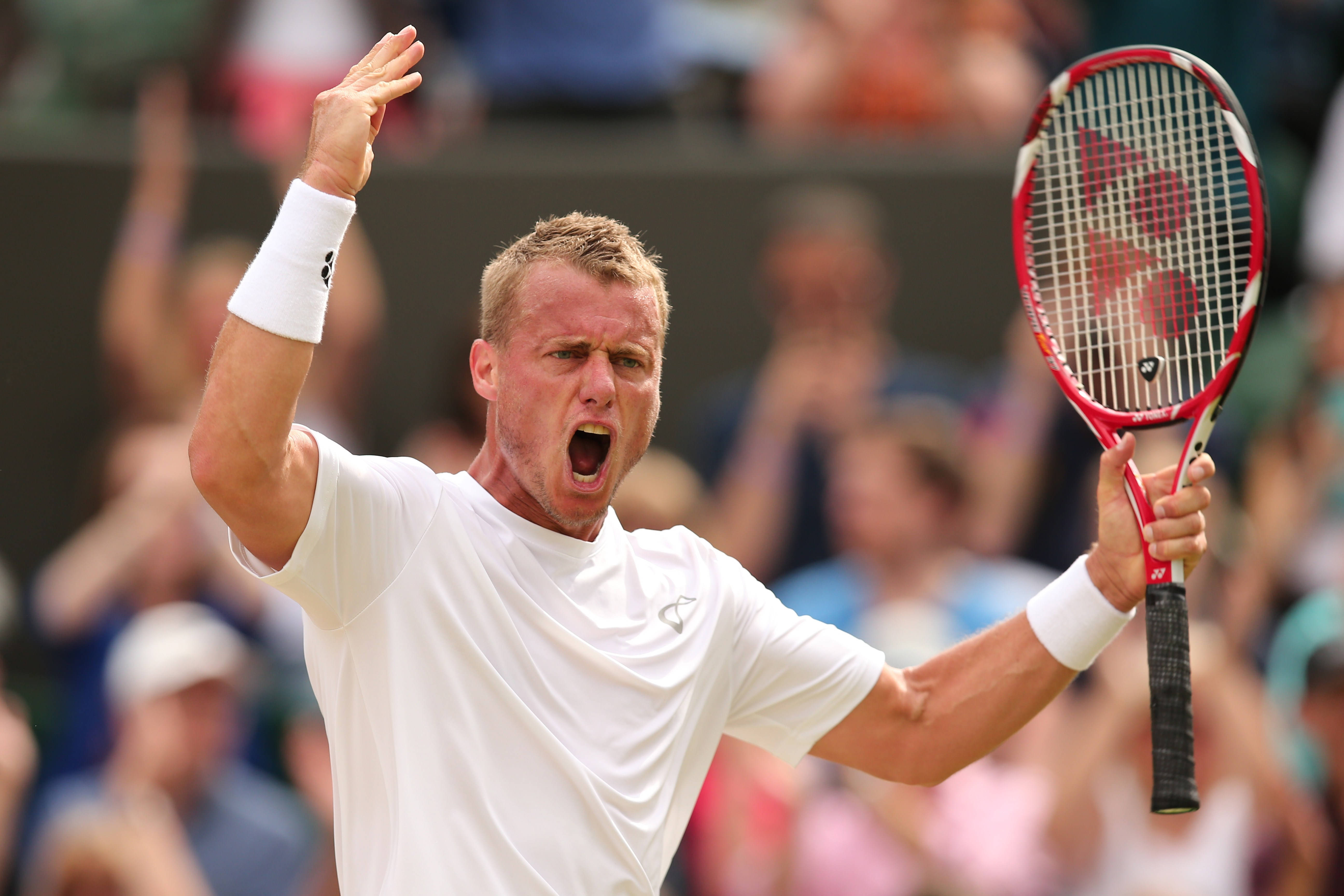 ATP澳洲網球選手 萊頓·休伊特 壁紙 — 一名身穿白色襯衫和護腕的男網球運動員，在陽光照耀的球場上，一手握著紅色球拍，另一手高舉，發出勝利的吶喊。