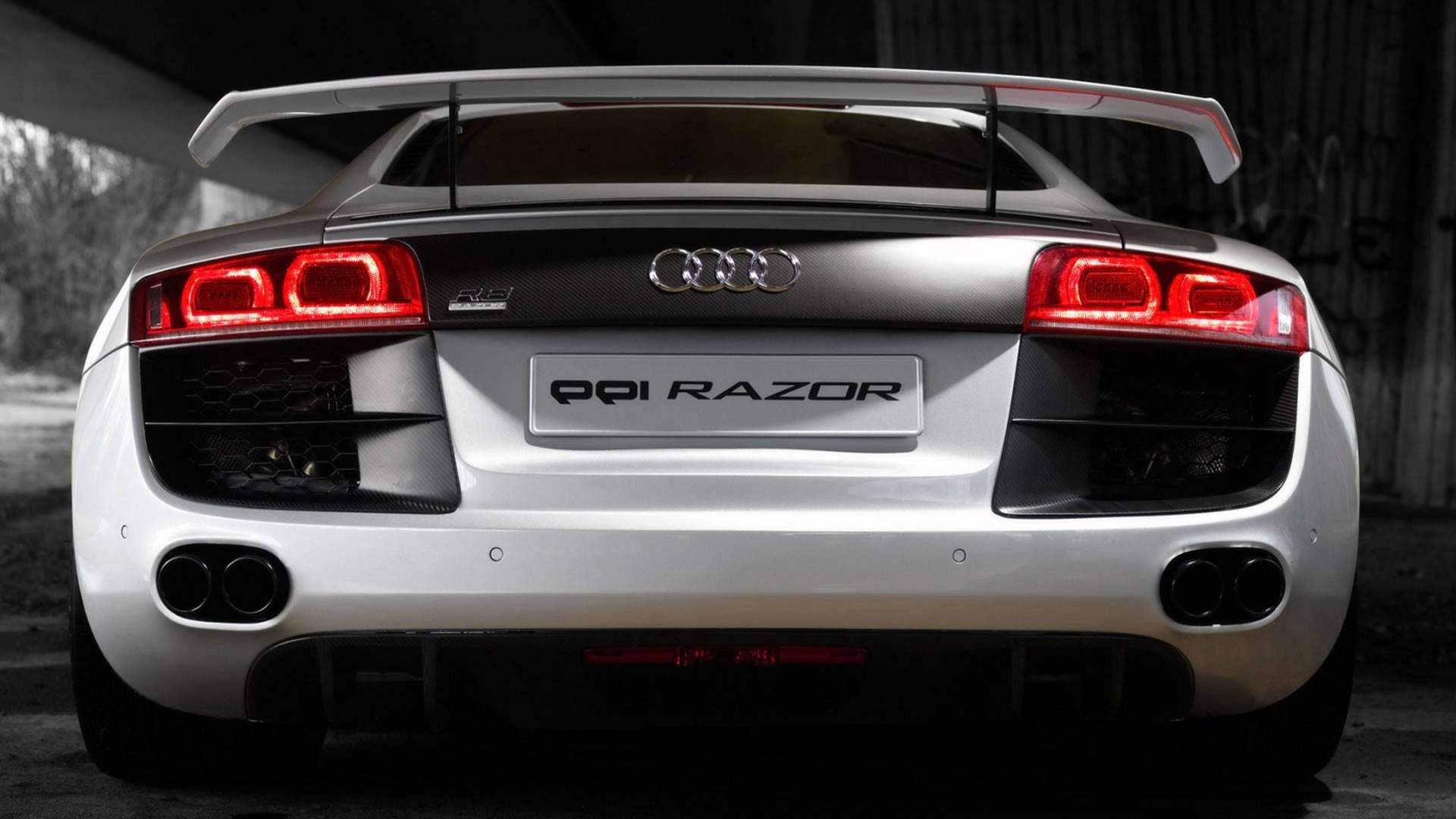 奢華之光 - Audi R8 PPI Razor 壁紙 — 一輛時尚的銀色奧迪R8跑車，帶有紅色尾燈和大型後擾流板，停在混凝土天橋下。