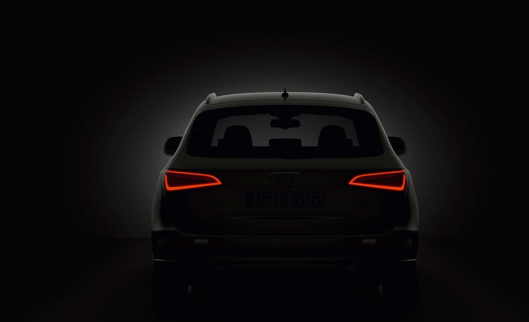 Audi Q5 桌布 壁紙 — Audi SUV 尾部輪廓，紅色尾燈在黑暗工作室背景下發光。
