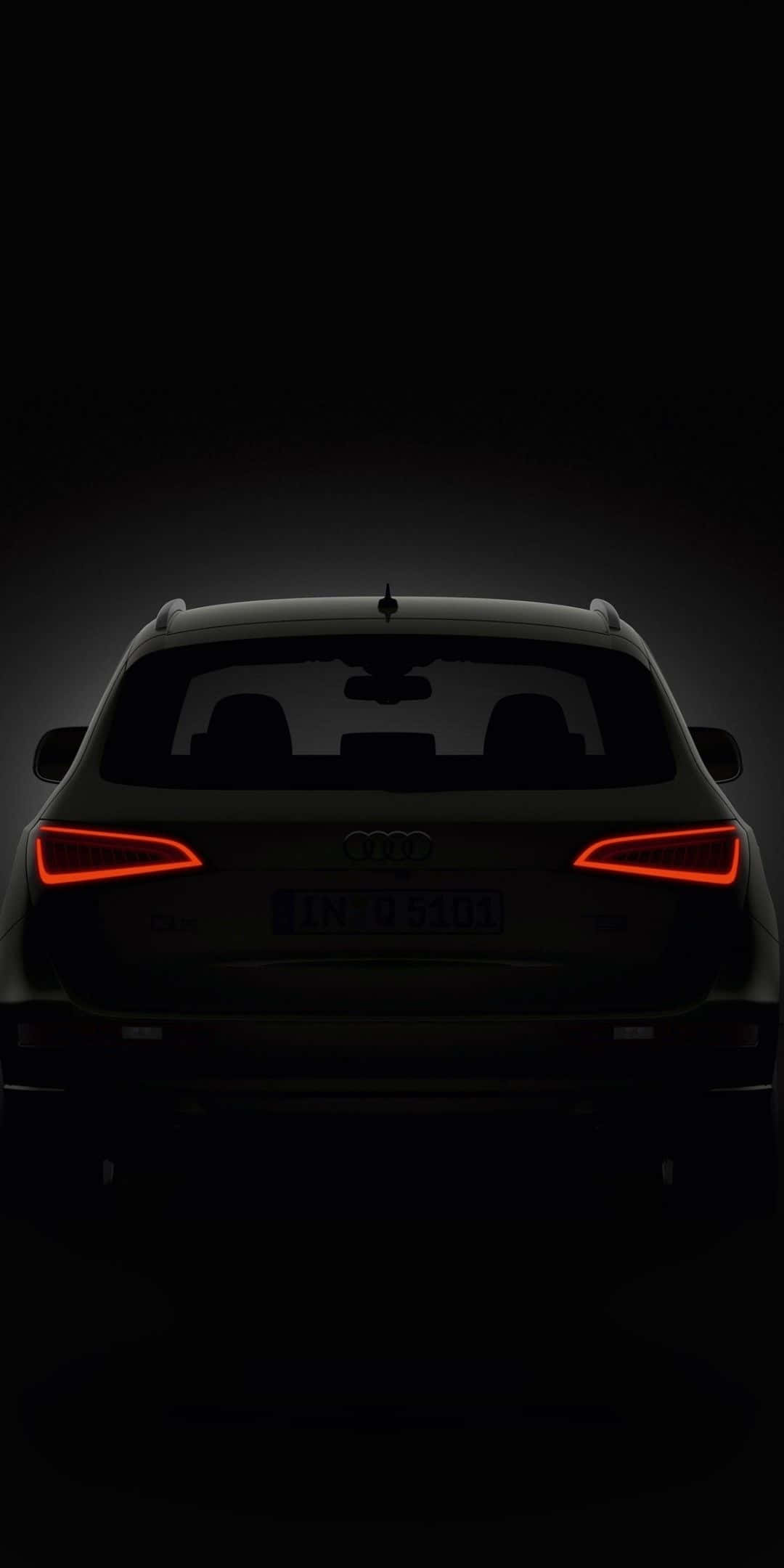 Audi Q5 桌布 壁紙 — Audi SUV 車尾輪廓，紅色尾燈在漆黑背景中發光。