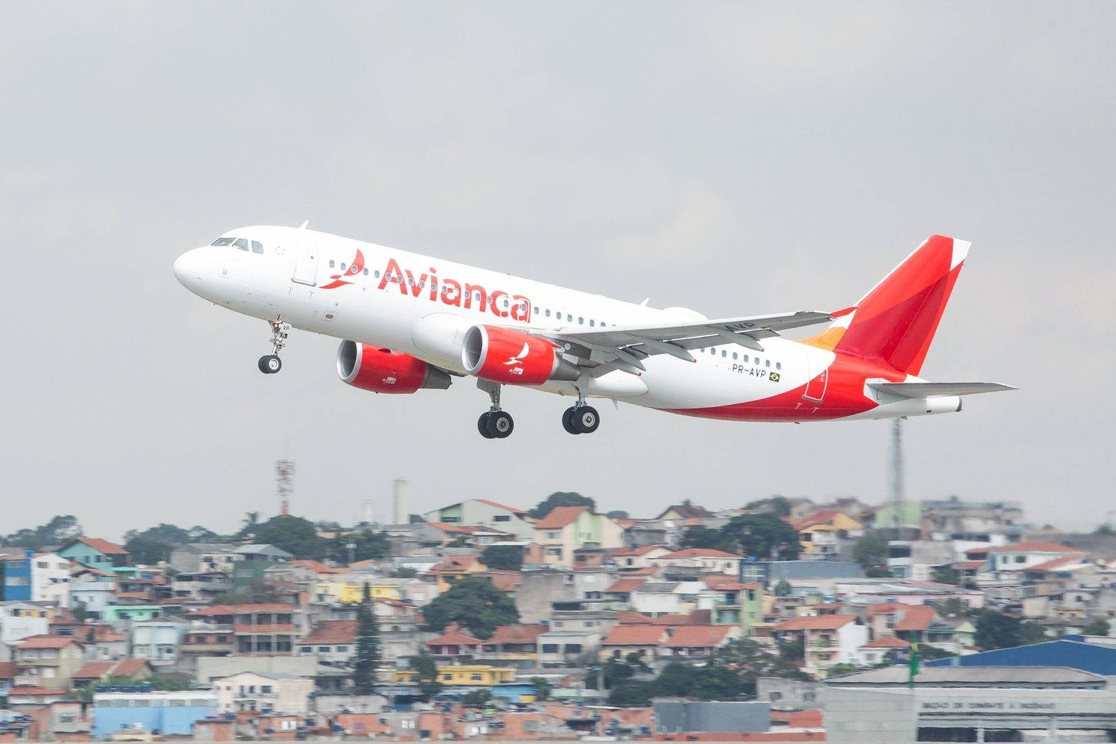 Avianca 客機在住宅區上空爬升。