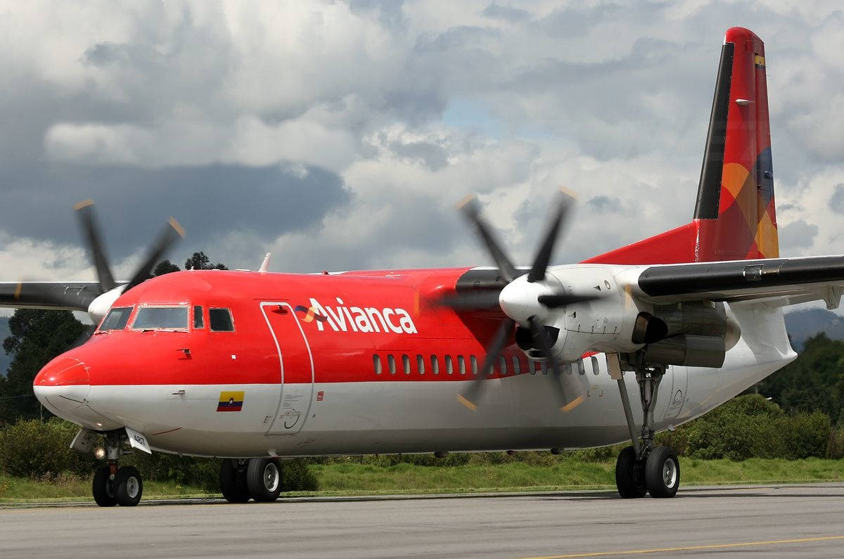 陰天下，機場停機坪上的紅白 Avianca 螺旋槳飛機。