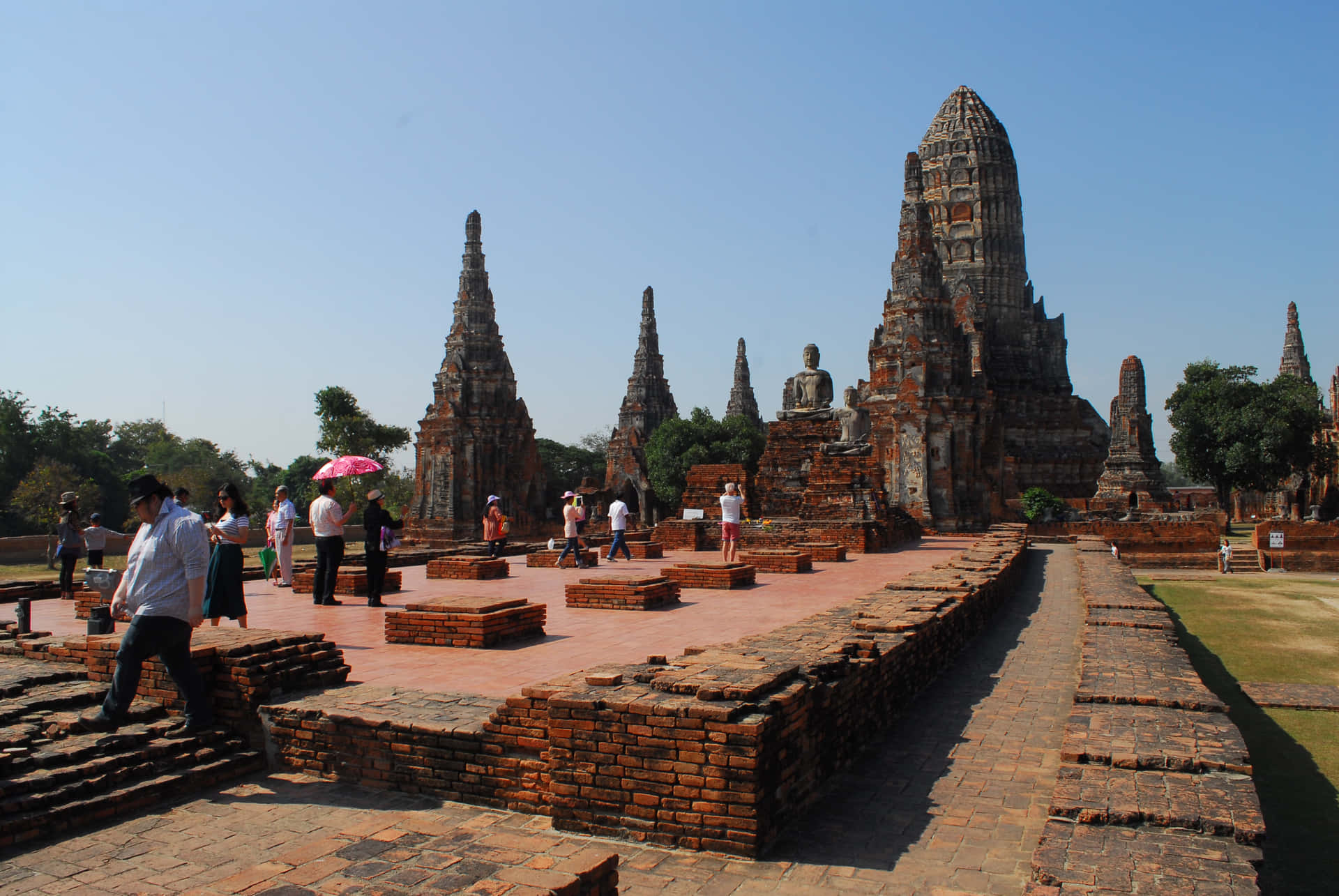 Ayutthaya歷史公園壯麗日落 壁紙 — 泰國大城府藍天白雲下，遊客探索古磚寺廟遺址。