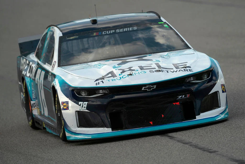 B.J. McLeod 駕駛淺藍色NASCAR賽車 壁紙 — 一架青綠色和白色的NASCAR盃系列雪佛蘭賽車，編號78，在灰色瀝青賽道上疾馳。