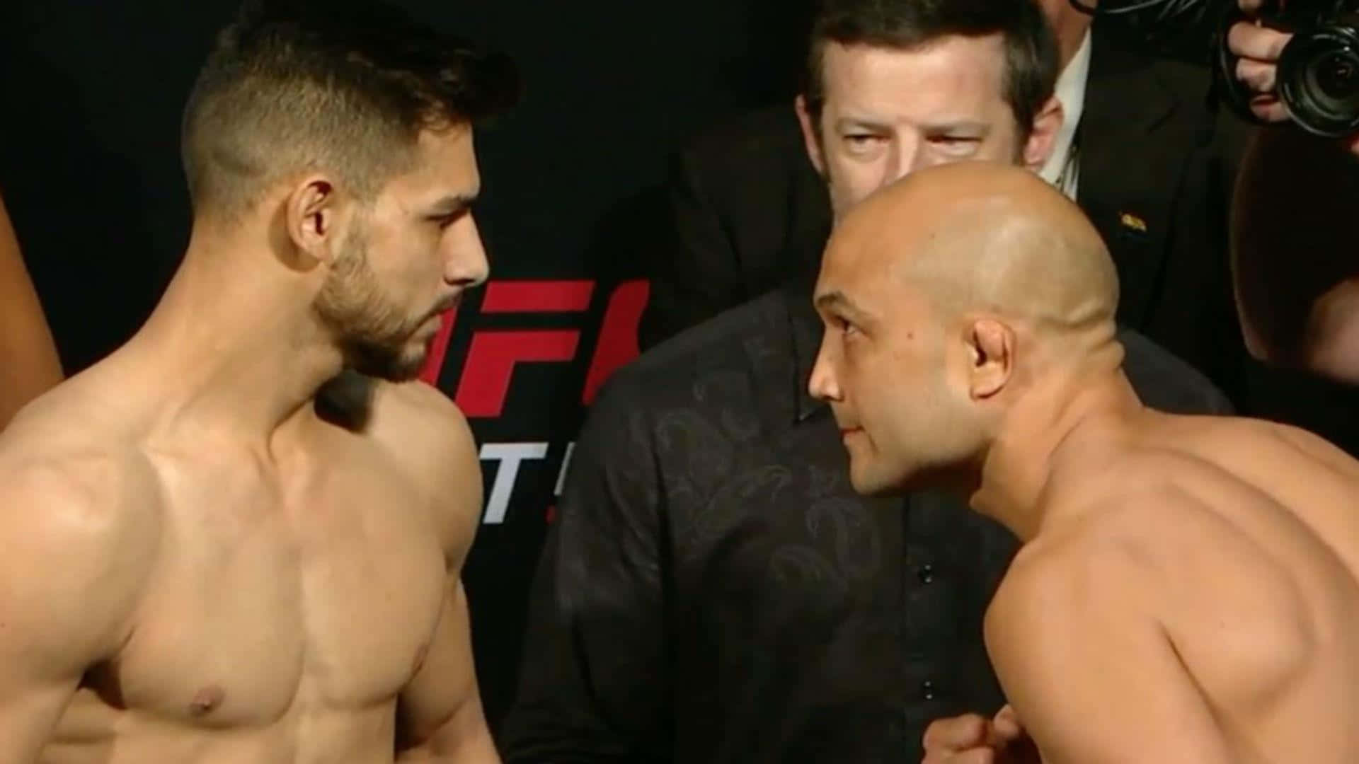 兩名赤裸上身的男性拳手在UFC稱重對決中四目交投。