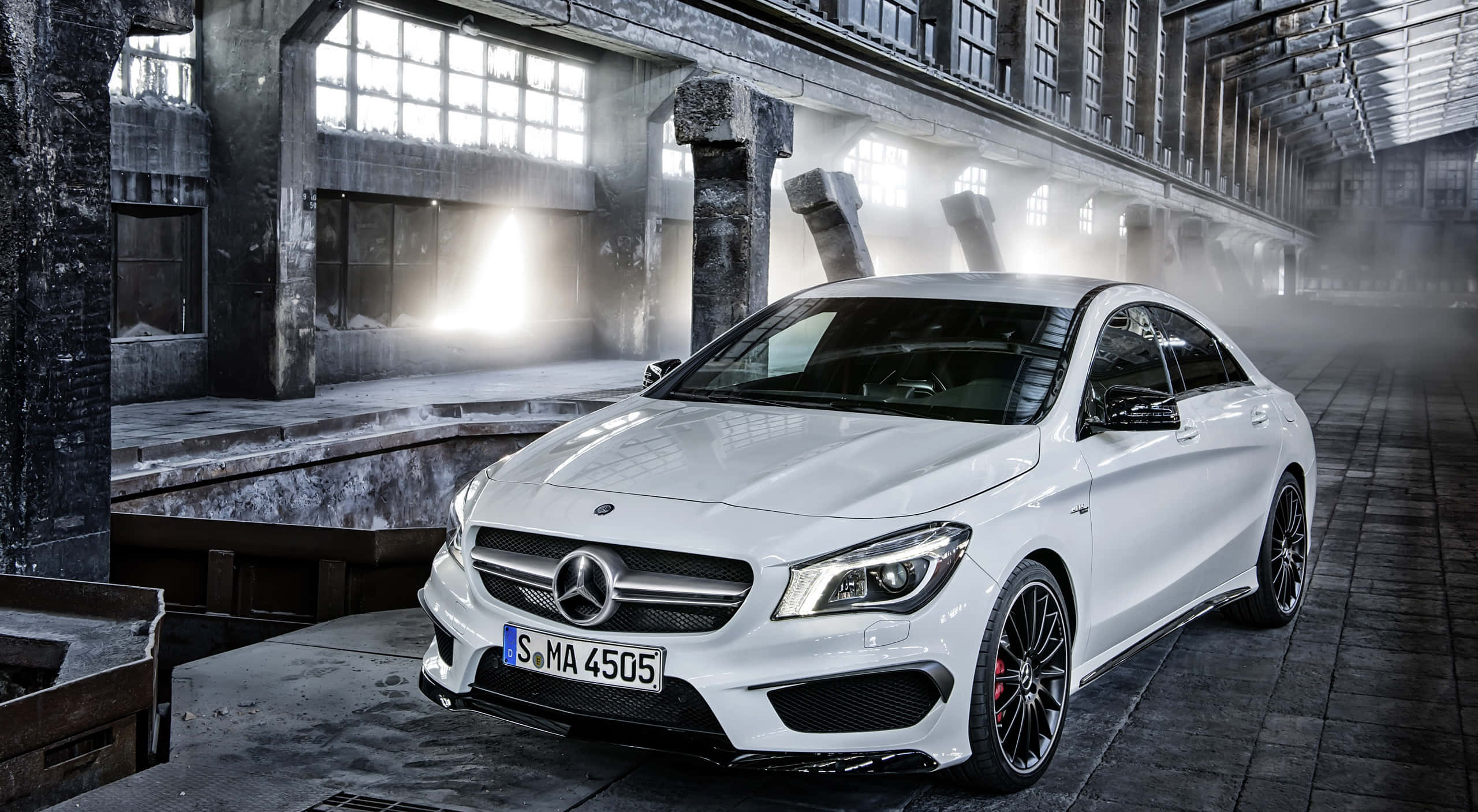 Mercedes Benz Cla-class 桌布 壁紙 — 一架流線型白色平治CLA 45 AMG跑車在霧氣籠罩的廢棄工廠內，於戲劇性的工業燈光下閃閃發光。