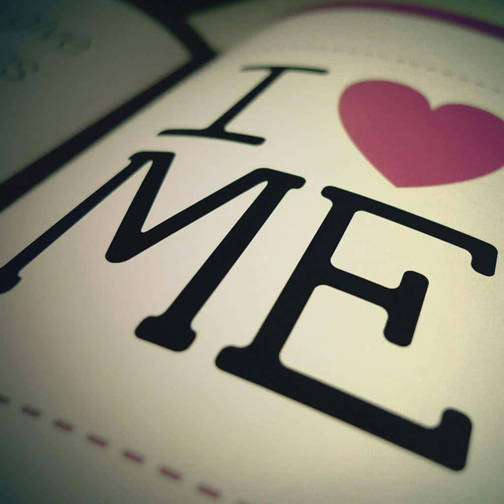  壁紙 — 白色表面上粗體黑色文字寫著「I ❤️ ME」並帶有粉紅色心形符號的特寫。