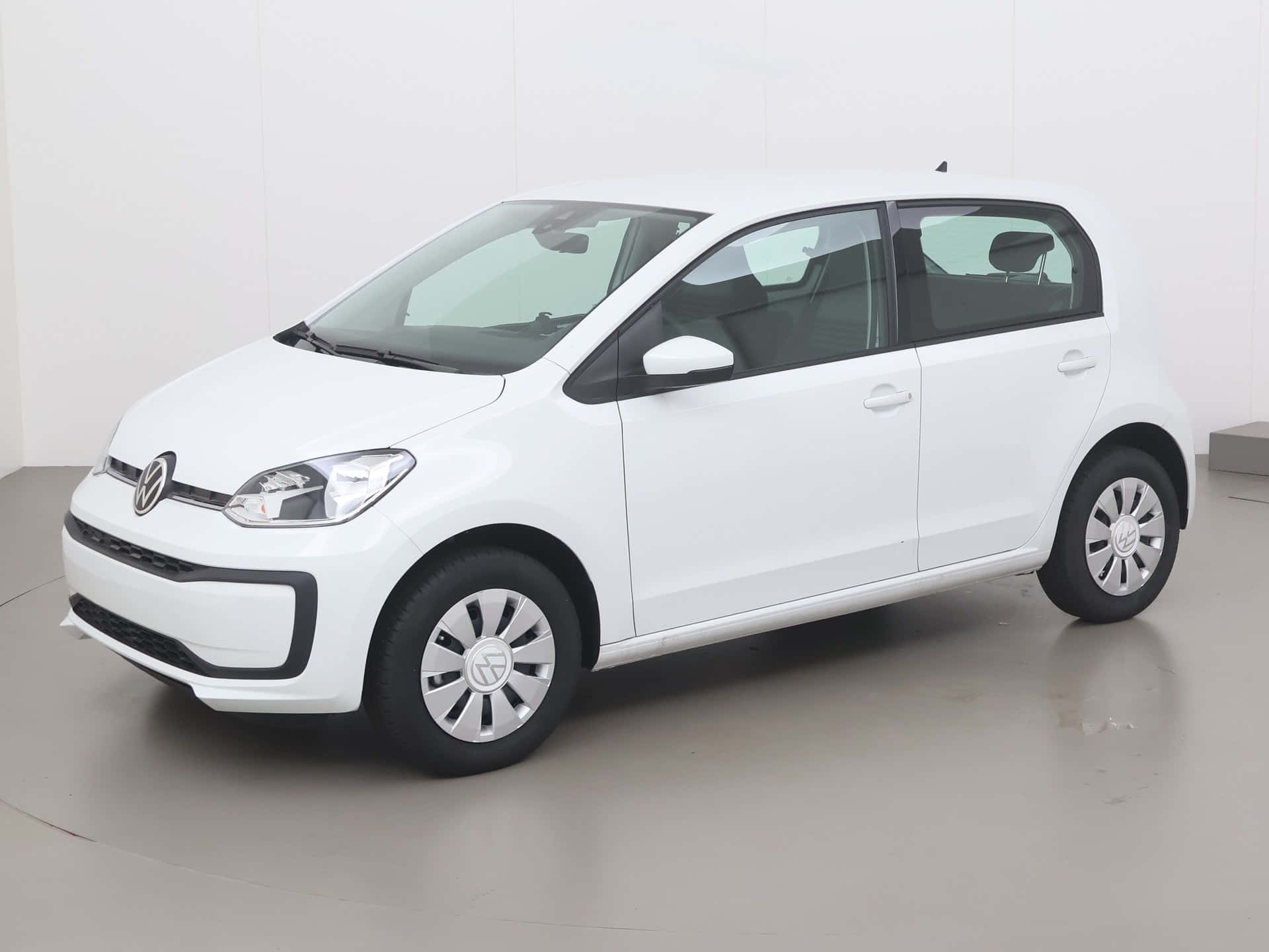  壁紙 — 一部純白色的Volkswagen up!小型房車在簡約風格的攝影棚中展示，線條簡潔，燈光柔和。