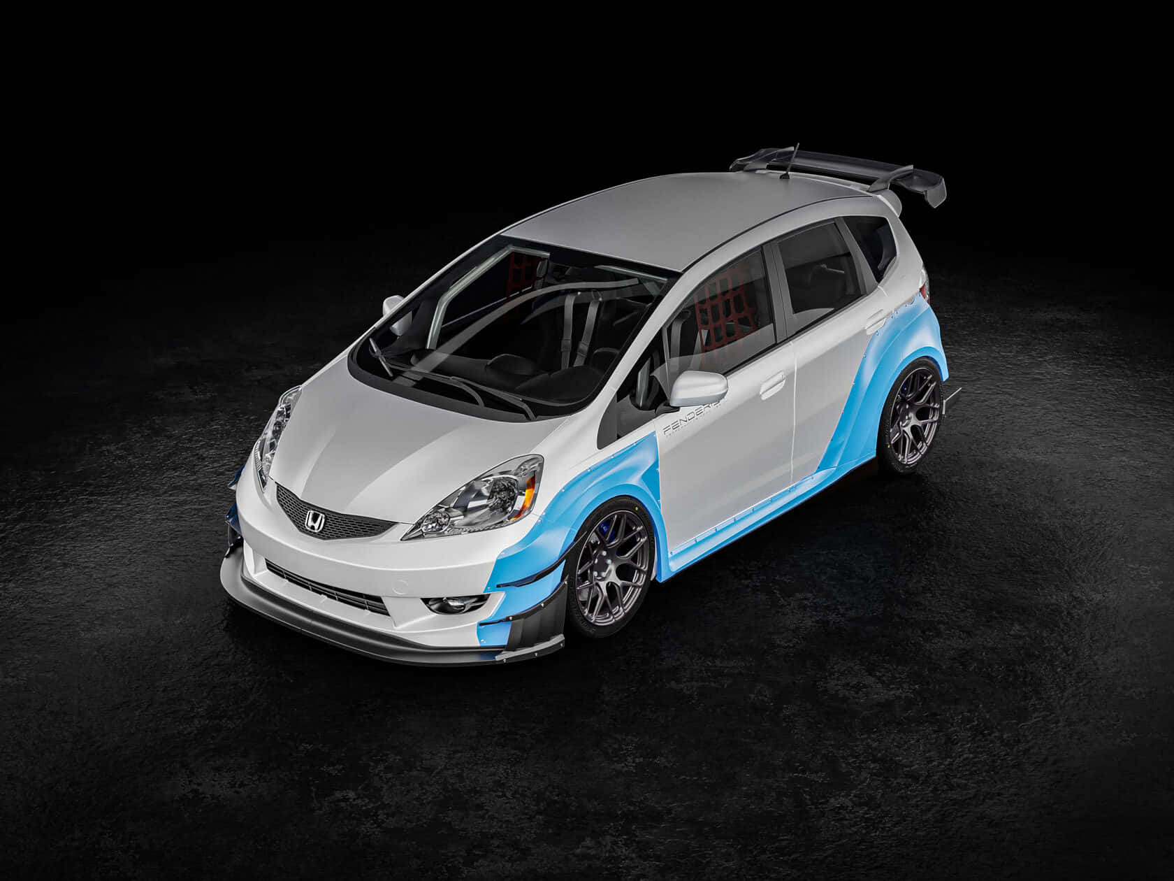Honda Fit 桌布 壁紙 — 一輛白色和藍色的改裝本田 Fit，配備黑色賽車輪圈和後擾流板，擺放在深色紋理工作室地板上。