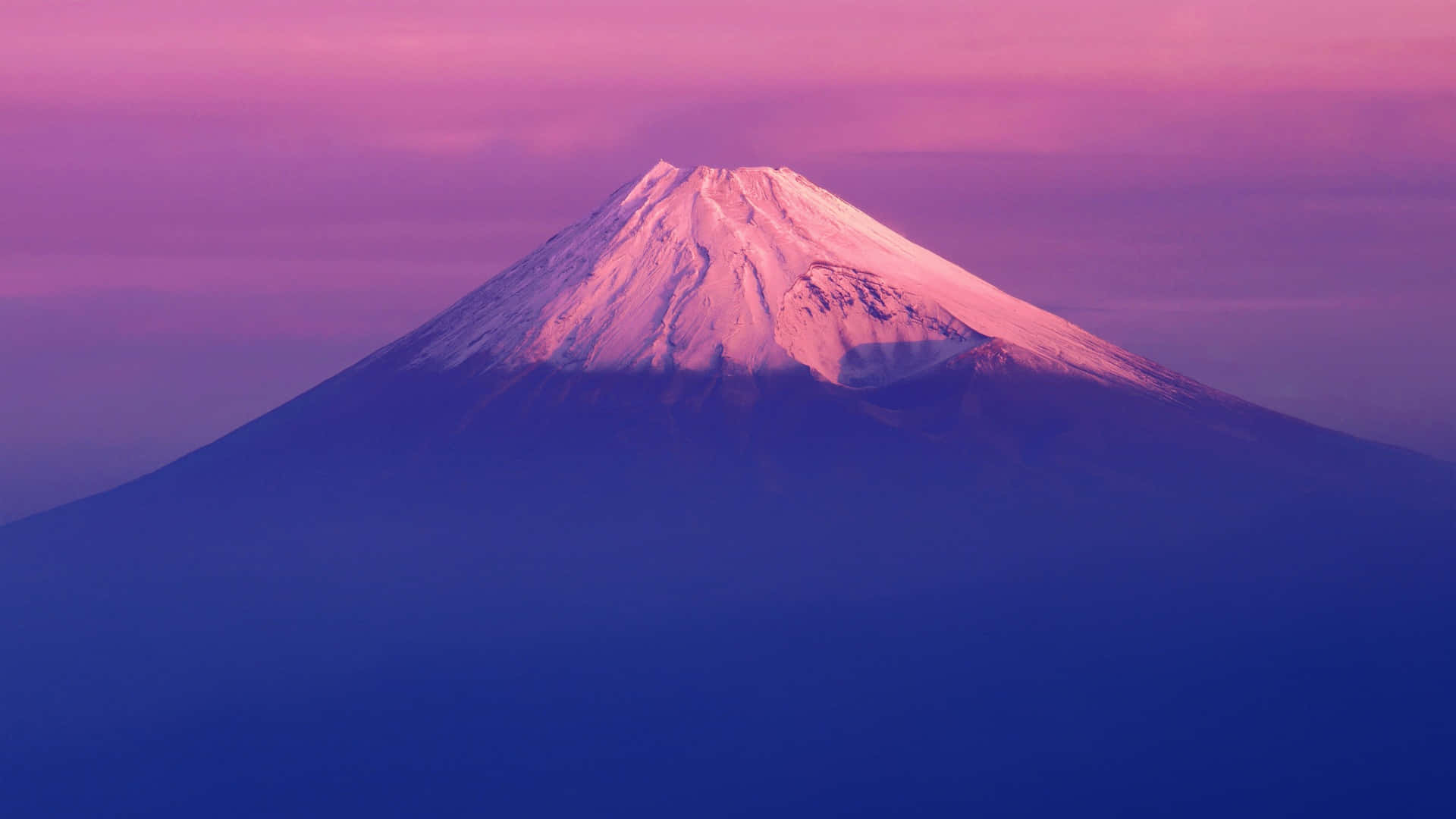  壁紙 — 白雪覆蓋的富士山在暮色天空下泛著粉紅和紫色，伴隨著柔軟的雲朵。