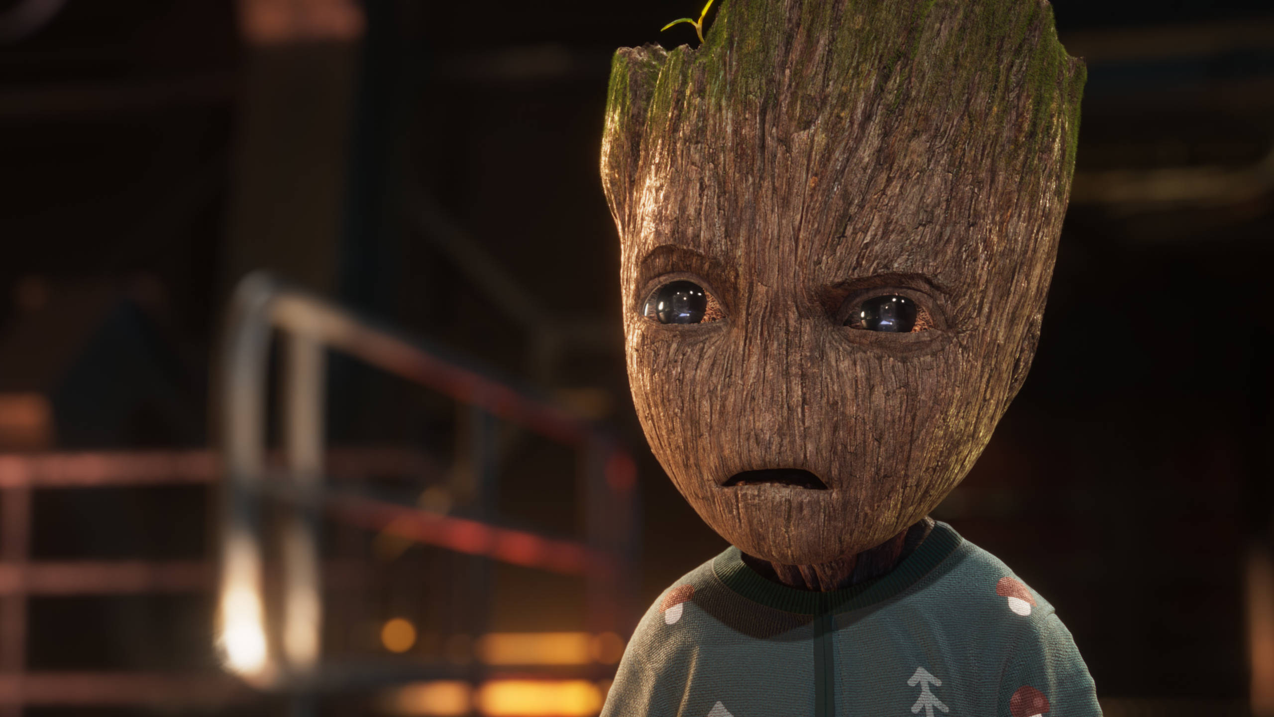 Baby Groot 穿著聖誕毛衣 壁紙 — 銀河守護隊中格魯特的近鏡，身穿節日毛衣，在溫暖的環境燈光下露出擔憂的表情。