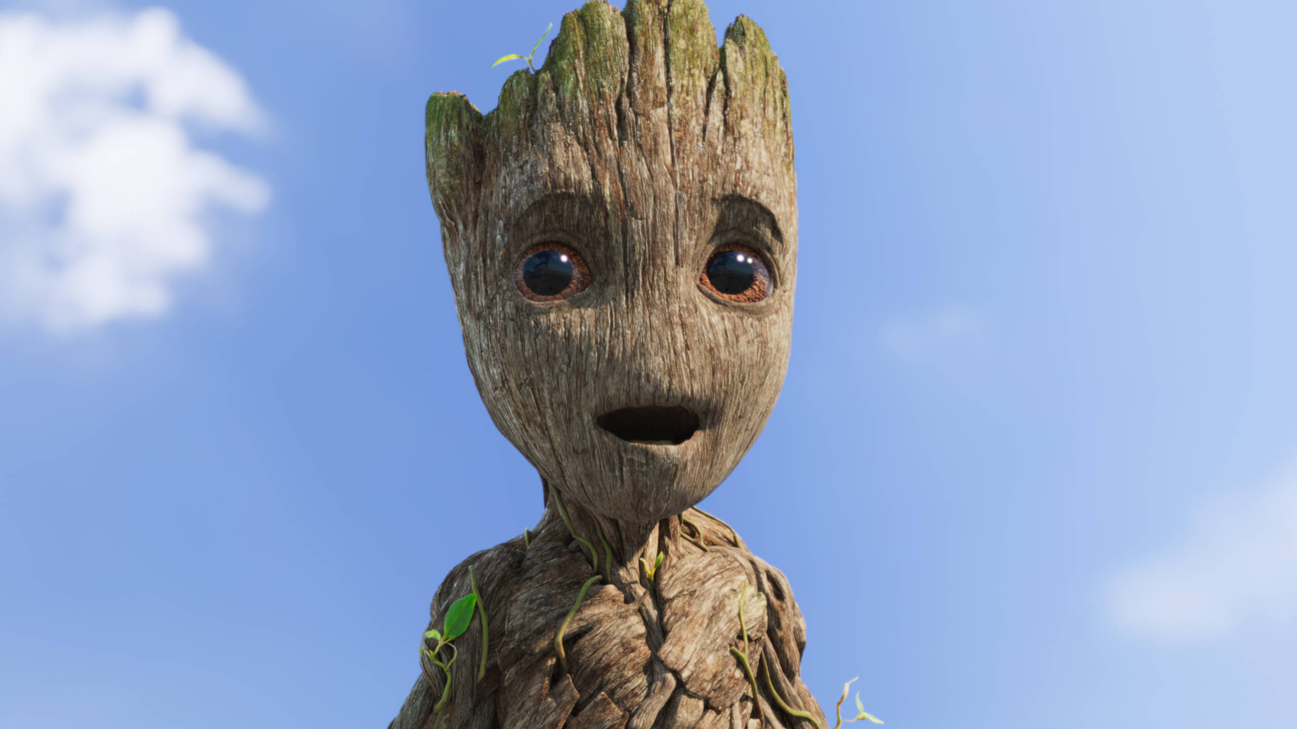 Baby Groot 驚訝表情 壁紙 — 格魯特表情豐富的臉部特寫，背景是清澈的藍天和柔軟的白雲。