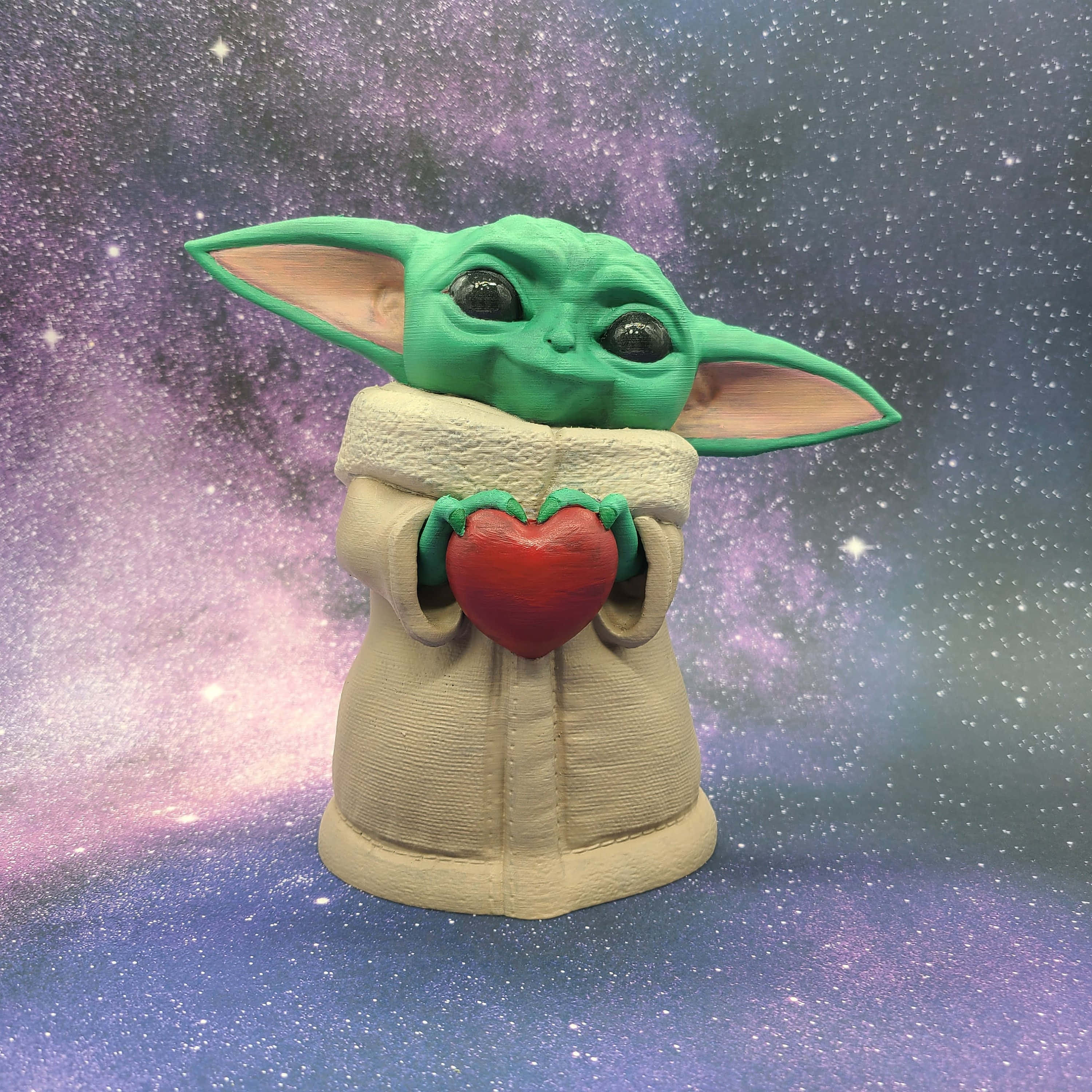 Baby Yoda 風格手持石頭 壁紙 — 一個穿著米色長袍的綠色嬰兒尤達公仔，在充滿活力的紫色和藍色星空銀河背景下拿著一顆紅心。