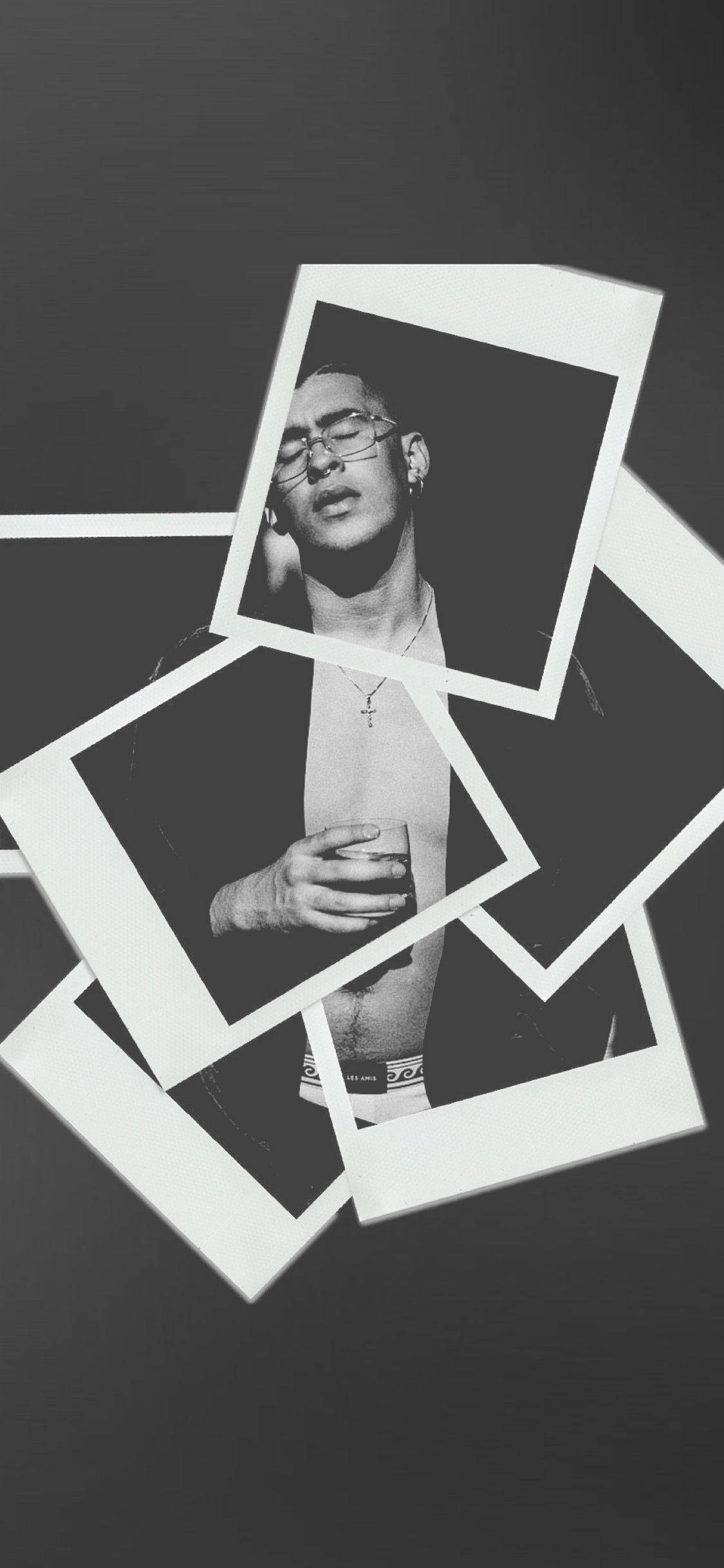 Bad Bunny 黑白寶麗來風格照片 壁紙 — 黑白寶麗來照片，一名戴眼鏡的男子手持飲品，疊加在深色背景上。