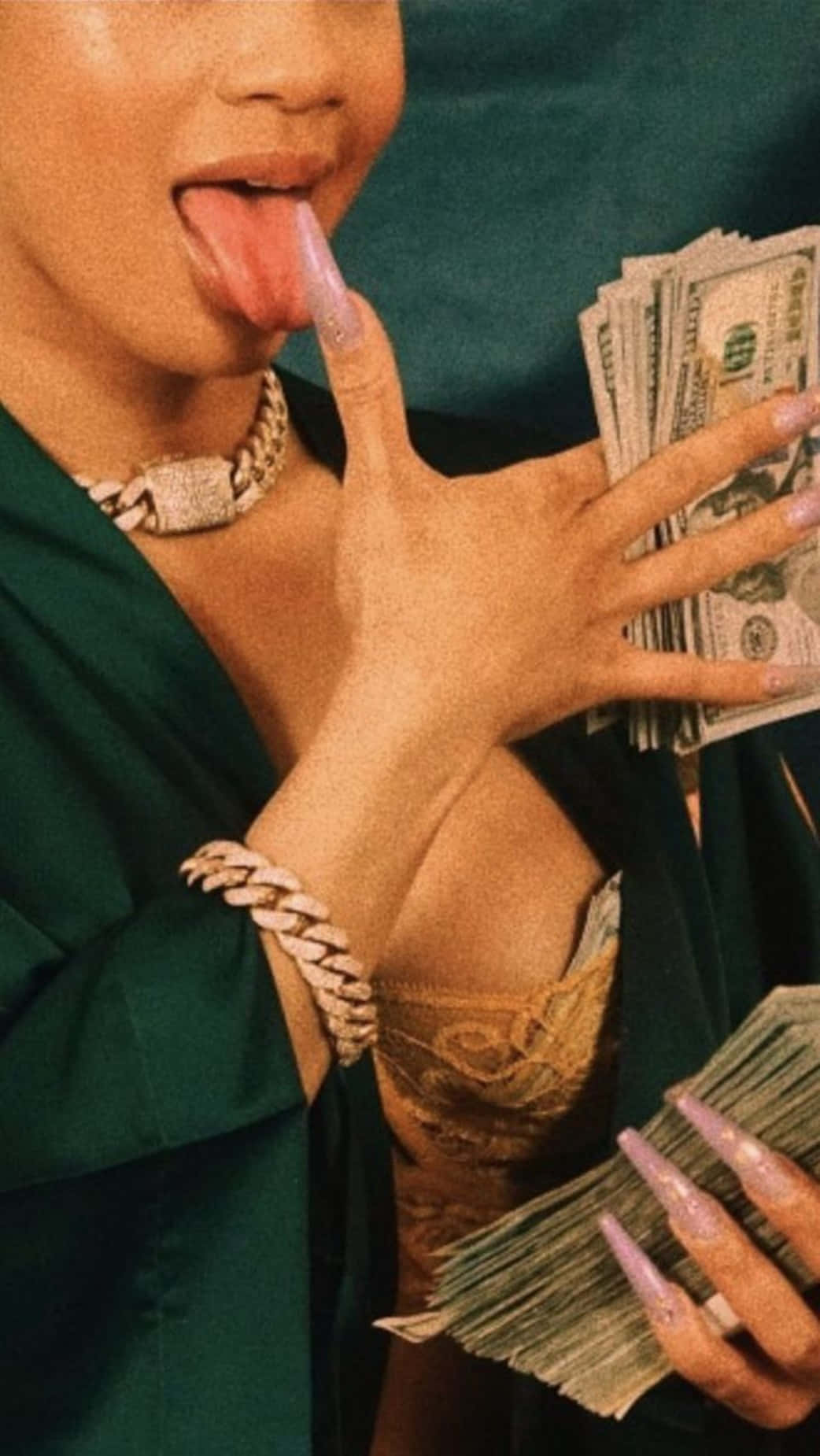 Baddie Money Girl 壁紙 — 一個穿著綠色長袍和金色珠寶的人頑皮地伸出舌頭，同時拿著一疊疊美元鈔票。