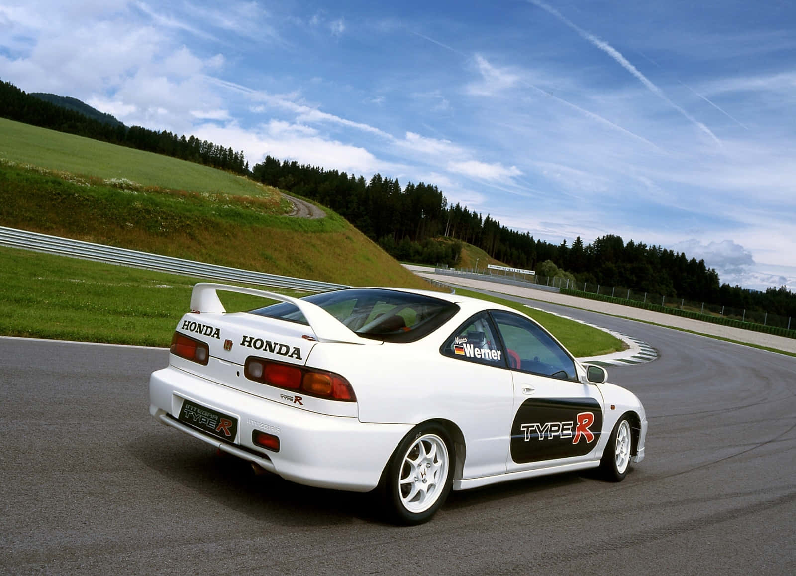 Honda Integra 桌布 壁紙 — 一輛白色本田Type R跑車在晴朗藍天和零星白雲下，沿著蜿蜒的賽道飛馳。