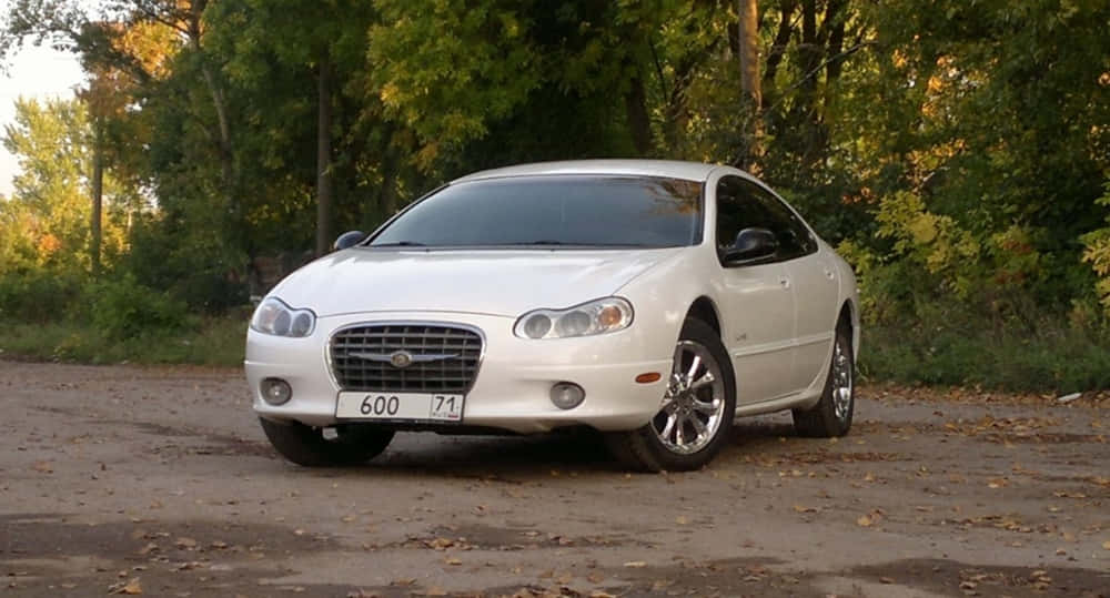Chrysler Lhs 桌布 壁紙 — 一輛白色克萊斯勒300轎車停在鋪滿落葉的泥路上，周圍是秋樹。