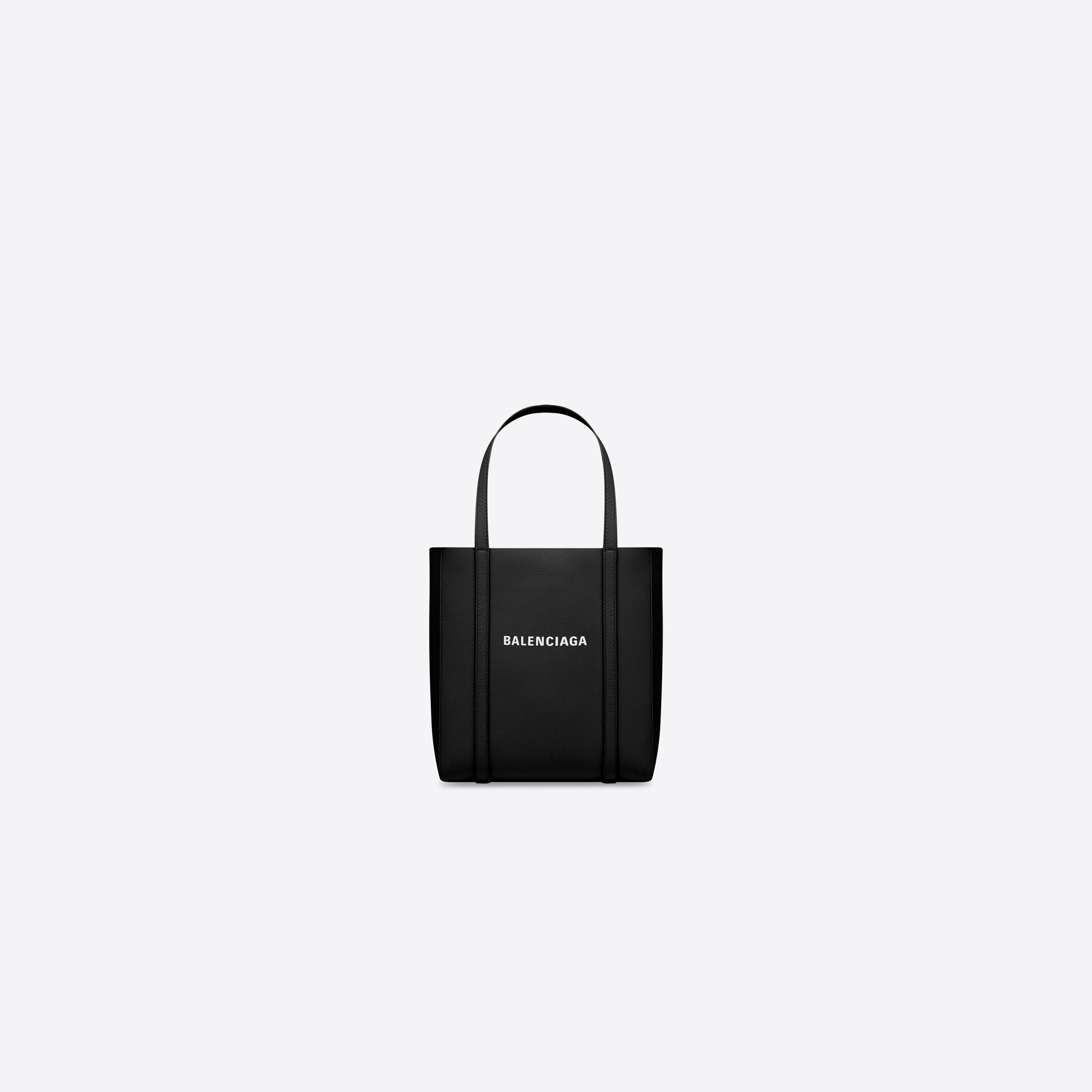 Balenciaga 托特包 壁紙 — 一個極簡風格的黑色Balenciaga托特包，帶有白色標誌，居中放置在純淺灰色背景上。