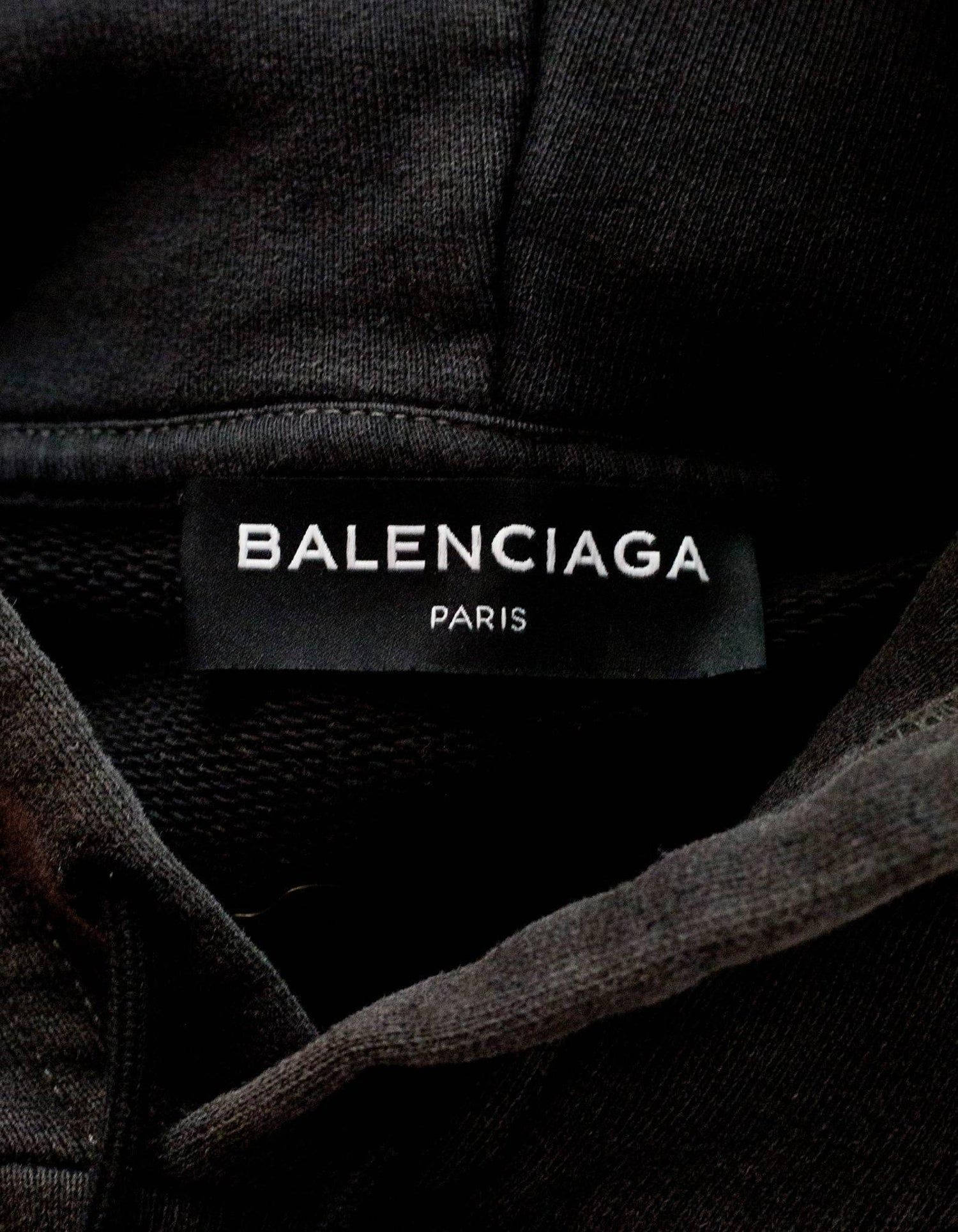 Balenciaga 服裝吊牌 壁紙 — 黑色Balenciaga Paris標籤近距離特寫，縫在深色紋理布料上，白色字體清晰。