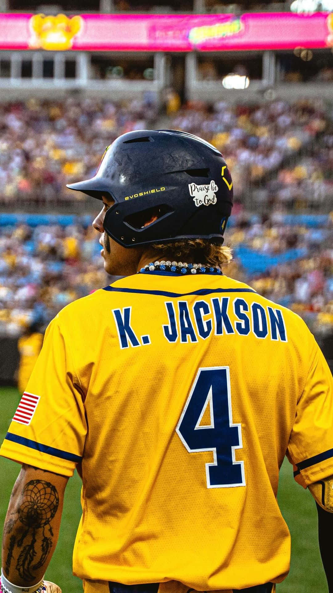  壁紙 — 一名身穿黃色球衣、名字為K Jackson、背號4的棒球選手站在球場上，面向人群，在球場燈光下。