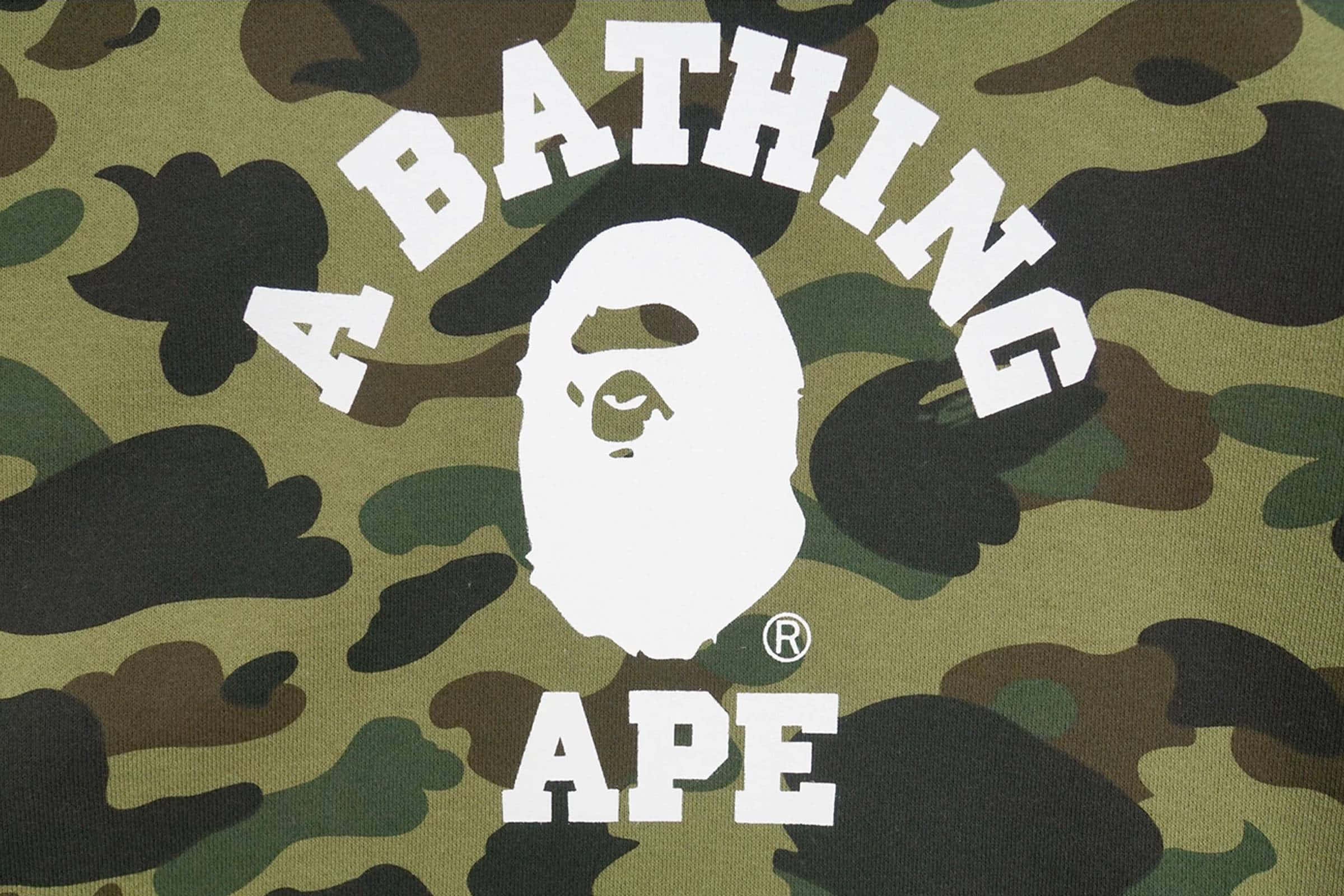 以BAPE展現你的個性 壁紙 — 迷彩布料特寫，帶有粗體白色A BATHING APE標誌及風格化猿頭。