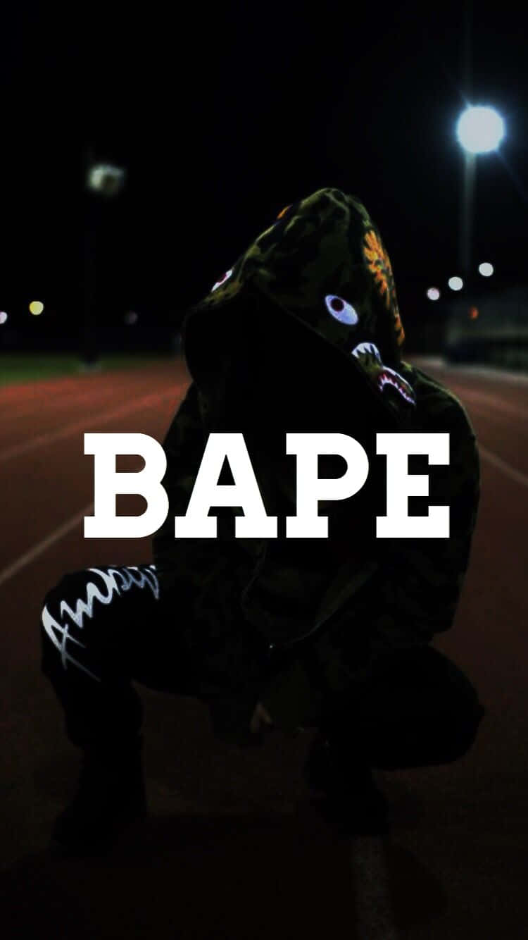 穿著BAPE老虎連帽衫的人夜晚蹲在黑暗的街道上。
