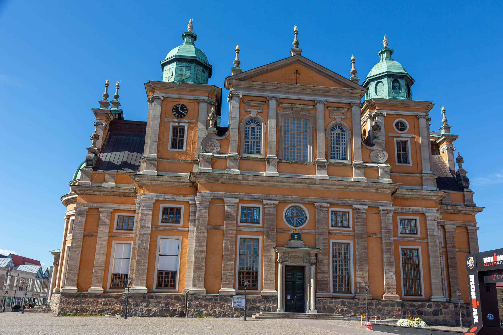 Kalmar Sweden 桌布 壁紙 — 宏偉的巴洛克大教堂，橙色外牆和綠色圓頂，在清澈的藍天下。