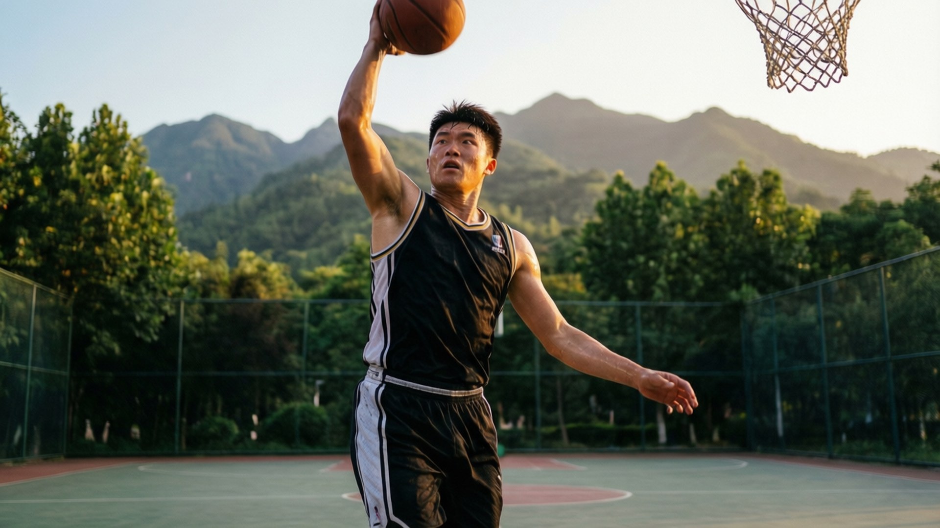 年輕男子在戶外球場入樽，背後有山脈和樹木