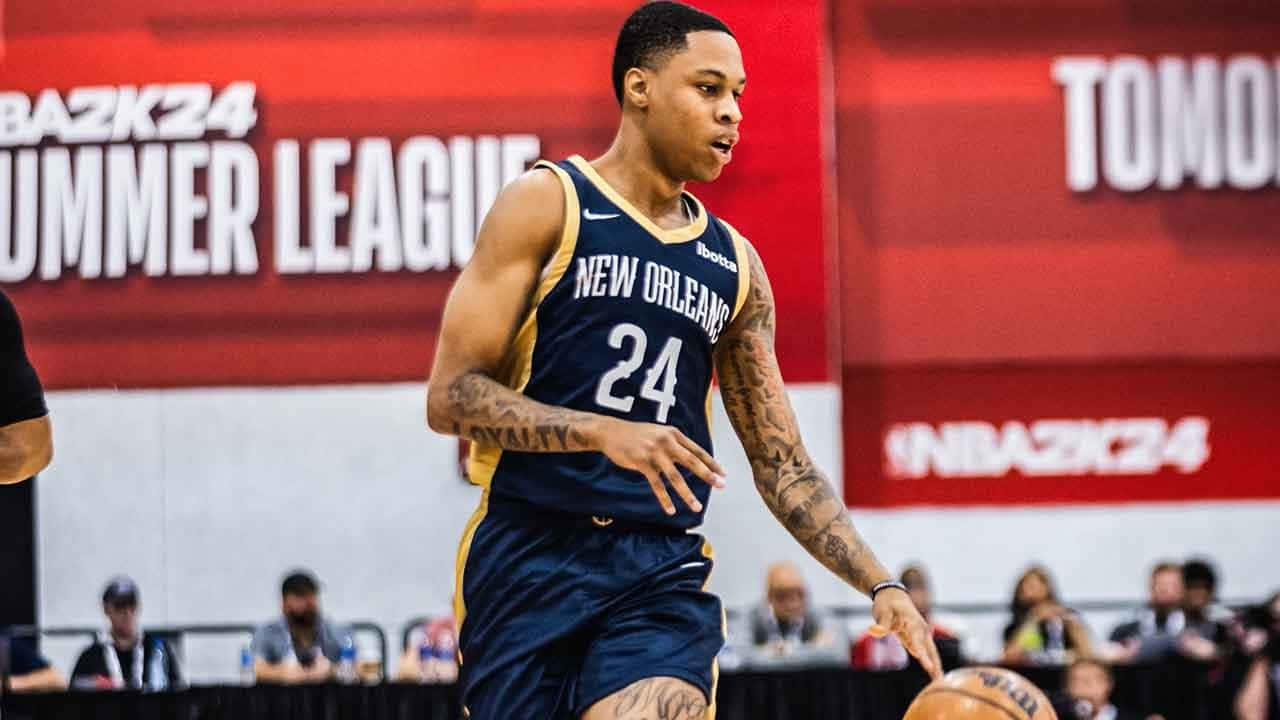  壁紙 — 一名身穿新奧爾良球衣的籃球運動員在明亮的場館燈光下，於NBA2K24夏季聯賽比賽中激烈運球。