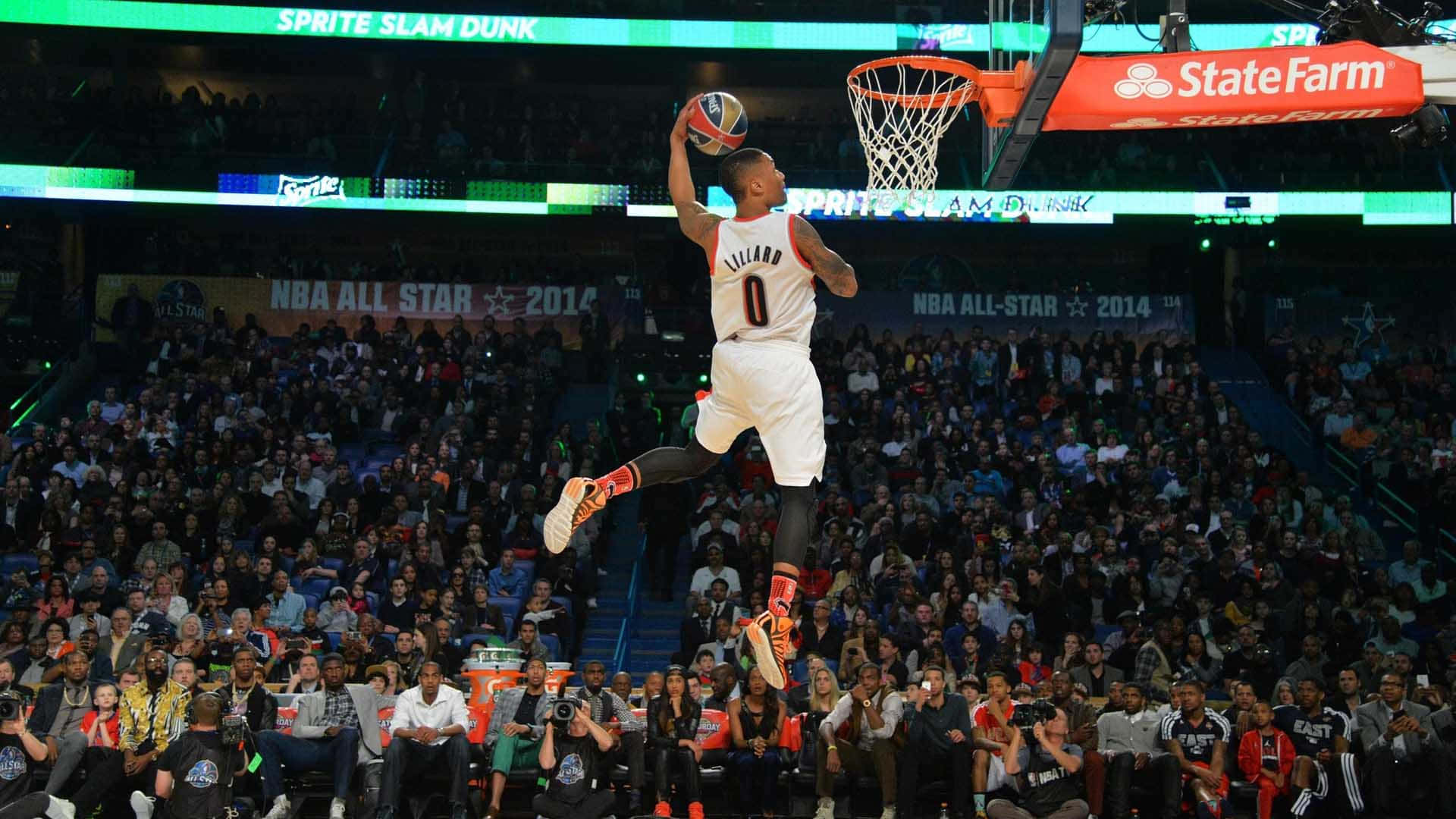  壁紙 — 在明亮的場館燈光下，一名籃球運動員在2014年NBA全明星灌籃大賽中空中灌籃。