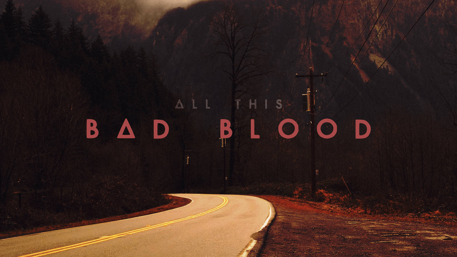 Bastille《Bad Blood》專輯封面 壁紙 — 一條蜿蜒的道路在黃昏時分穿過霧氣瀰漫的山谷，上面覆蓋著粗體紅色文字，寫著「ALL THIS BAD BLOOD」。