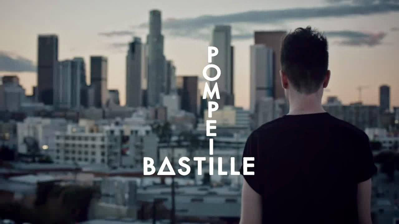 Bastille《Pompeii》城市風景 壁紙 — 一個人背對相機，俯瞰黃昏時分廣闊的城市天際線，並帶有文字疊加。
