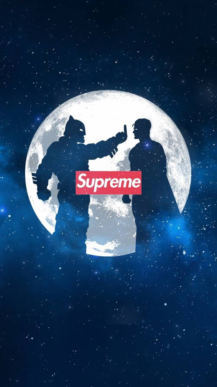 月球上 Batman 翻白眼 Superman 的剪影超級英雄壁紙 壁紙 — 蝙蝠俠和超人剪影襯托著滿月，兩者之間有一個紅色的Supreme標誌，背景是星空夜空。