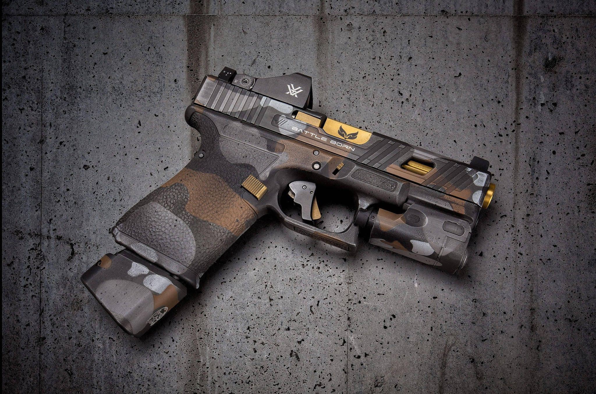 Battle Born 迷彩 Glock 壁紙 — 一把帶有金色裝飾的迷彩戰術手槍，在戲劇性燈光下放置在風化的混凝土表面上。