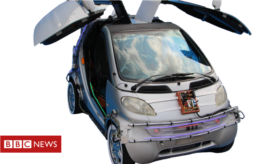 BBC新聞版《回到未來》德羅寧時光機 壁紙 — 一輛銀色未來汽車，鷗翼門打開，黑色背景，露出外露的佈線和電路。