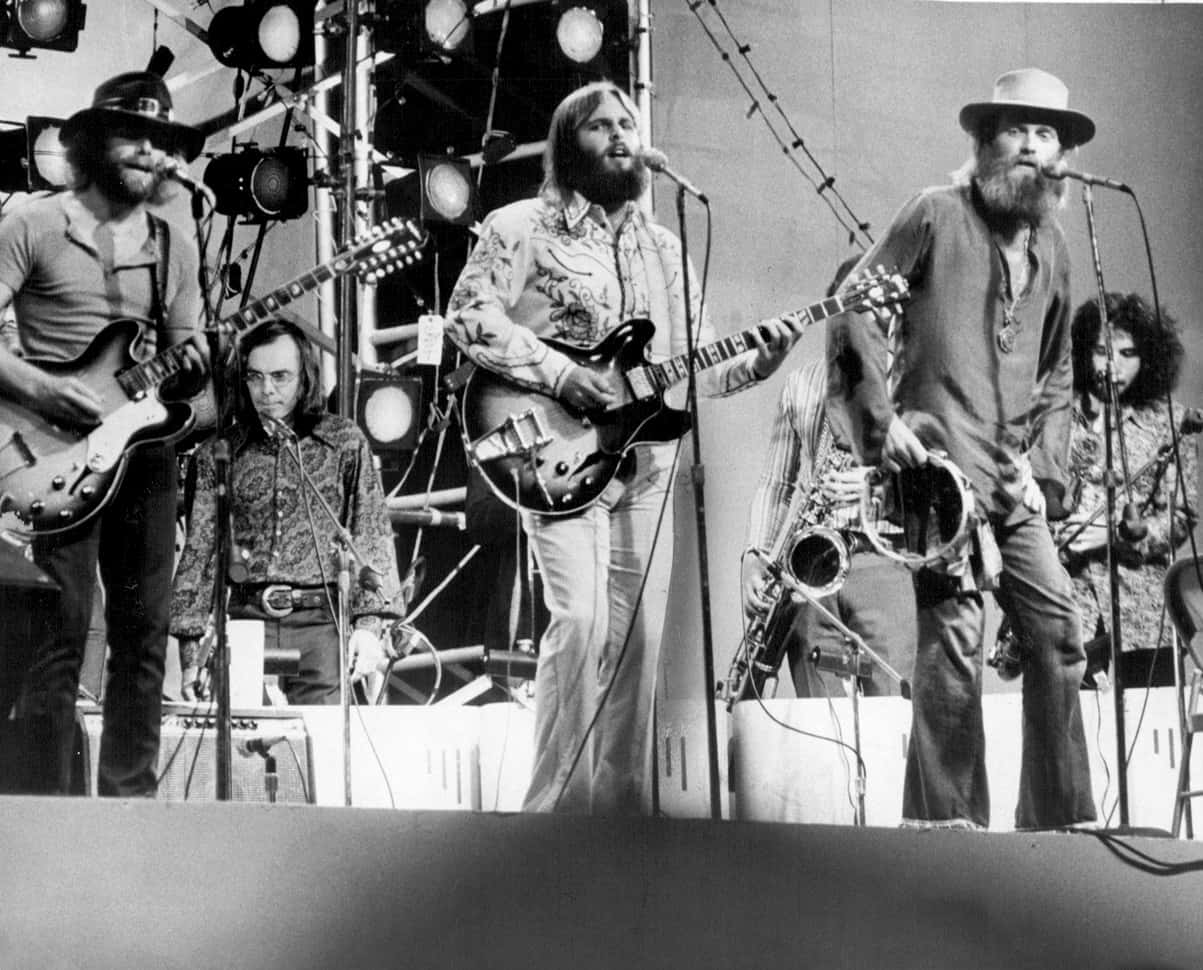 Beach Boys《Good Vibrations》中央公園演出 壁紙 — 一張1970年代搖滾樂隊在舞台燈光下用結他和色士風表演的黑白照片。