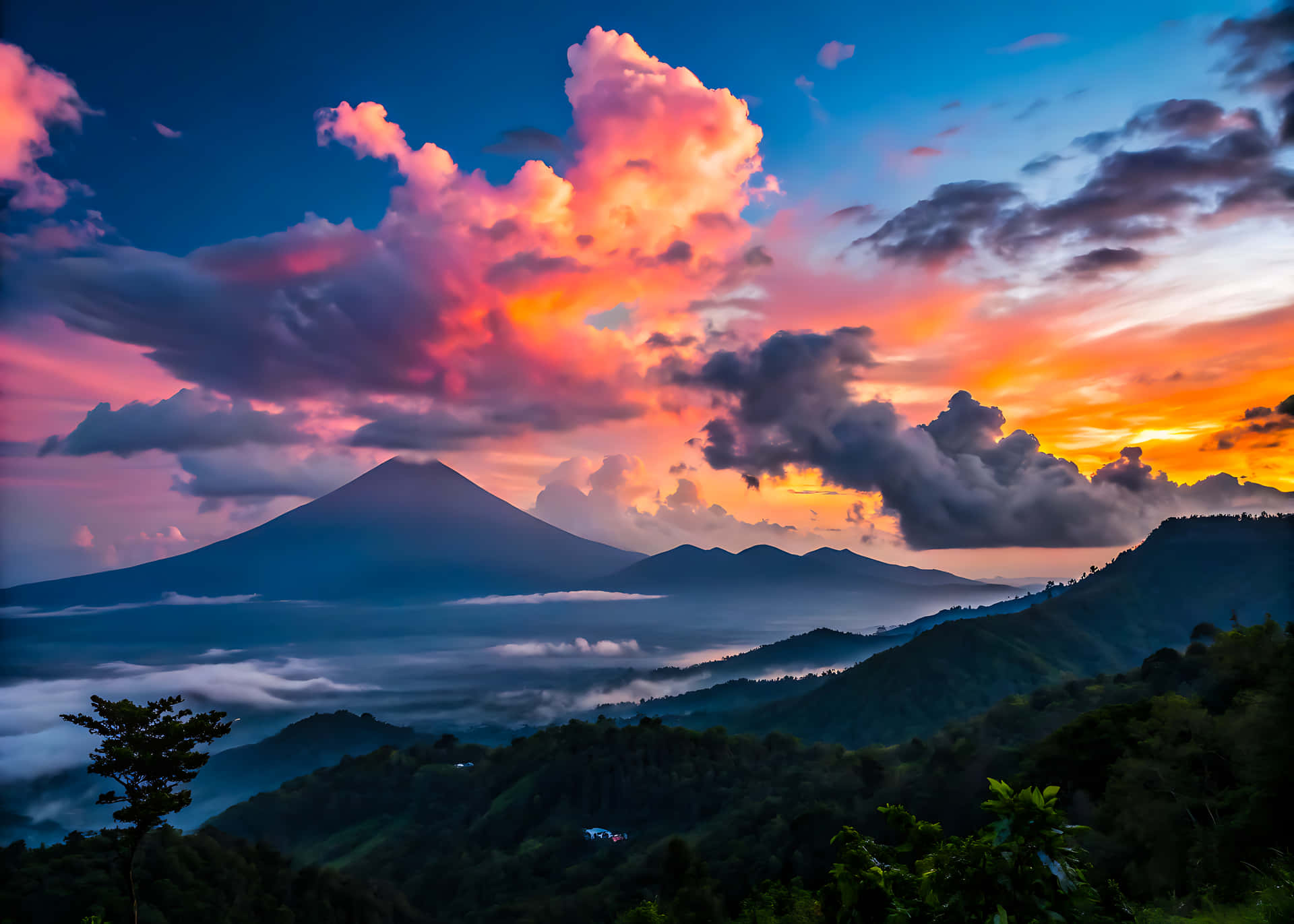 色彩繽紛的黎明時分，火山頂峰在霧雲之上，前景是森林覆蓋的山丘