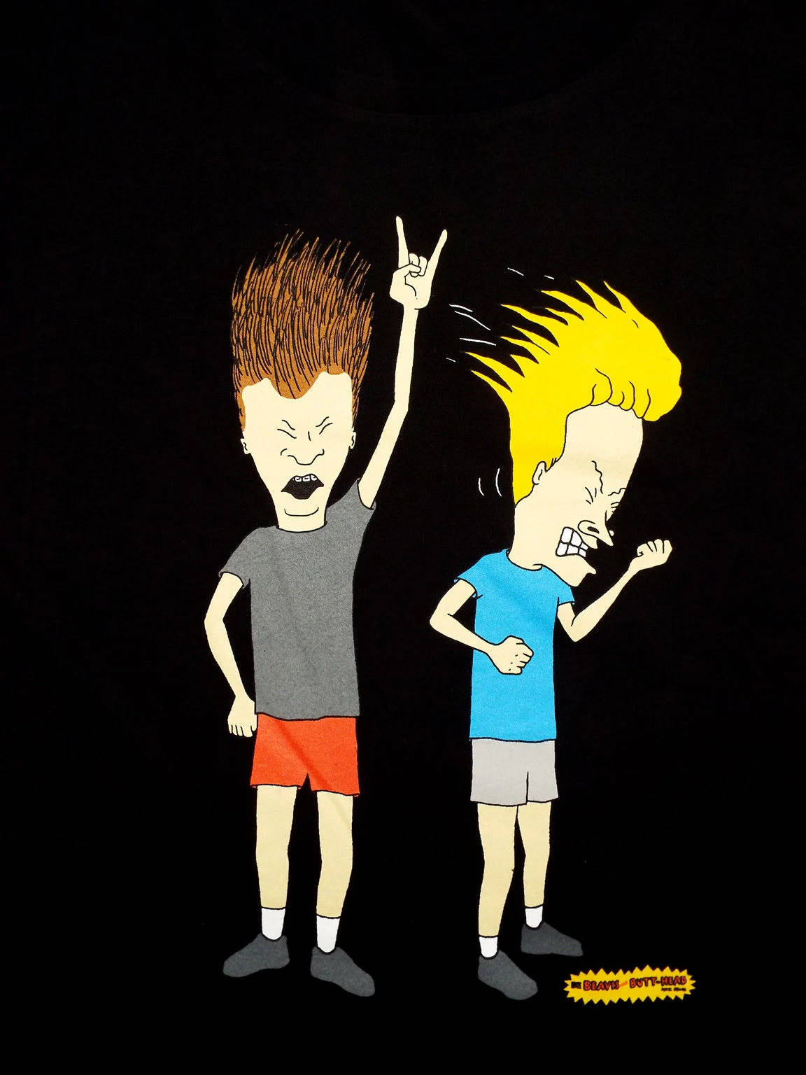 Beavis 和 Butt-Head 搞笑搖滾 壁紙 — 兩個卡通男孩，頭髮尖刺，在黑色背景上咄咄逼人地大喊，一個舉起和平手勢，另一個握緊拳頭。