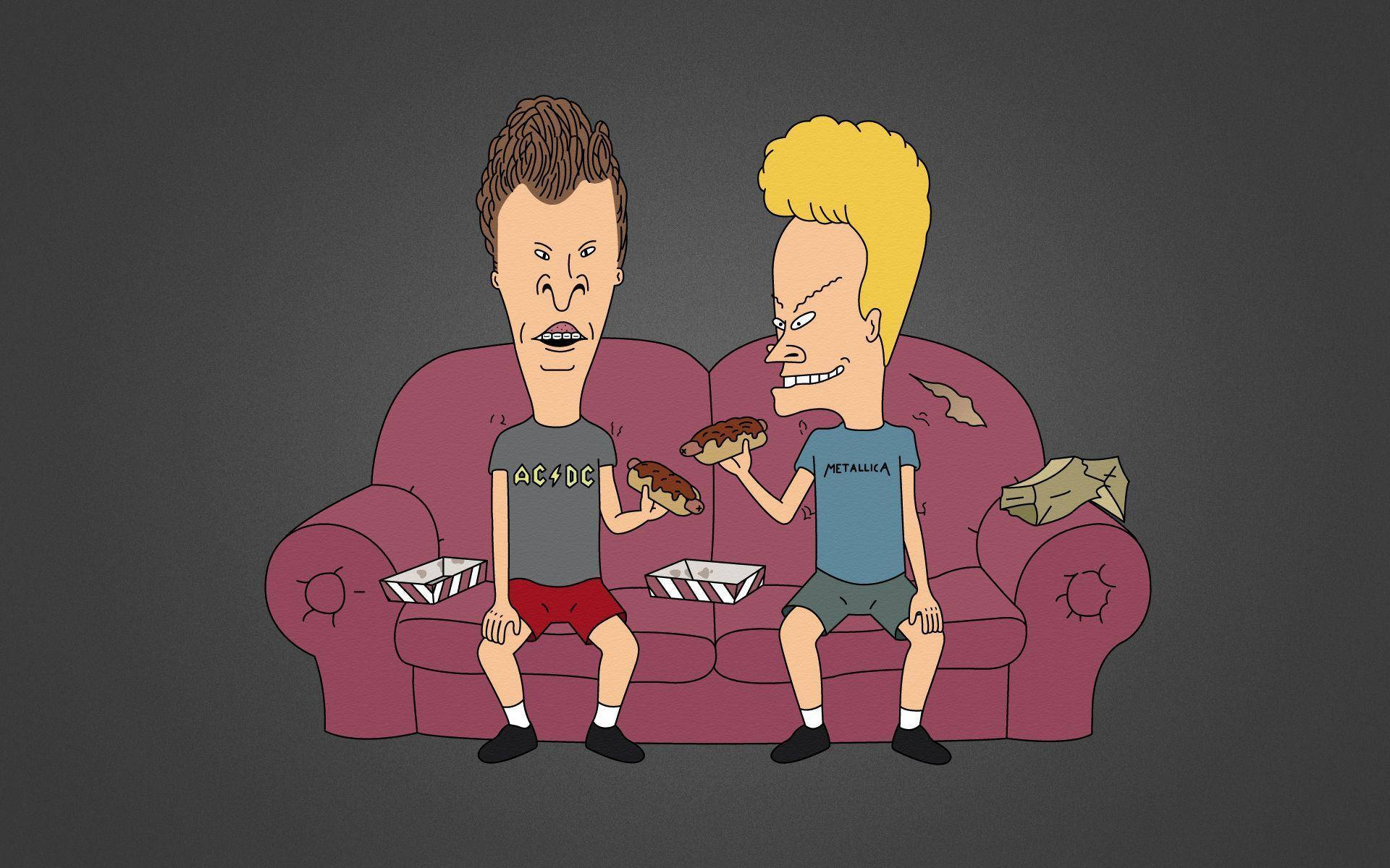 Beavis 和 Butt-Head 在沙發上吃熱狗 壁紙 — 兩個頭部誇張的卡通男人坐在一張破舊的紫色沙發上吃薄餅，並拿著外賣盒。