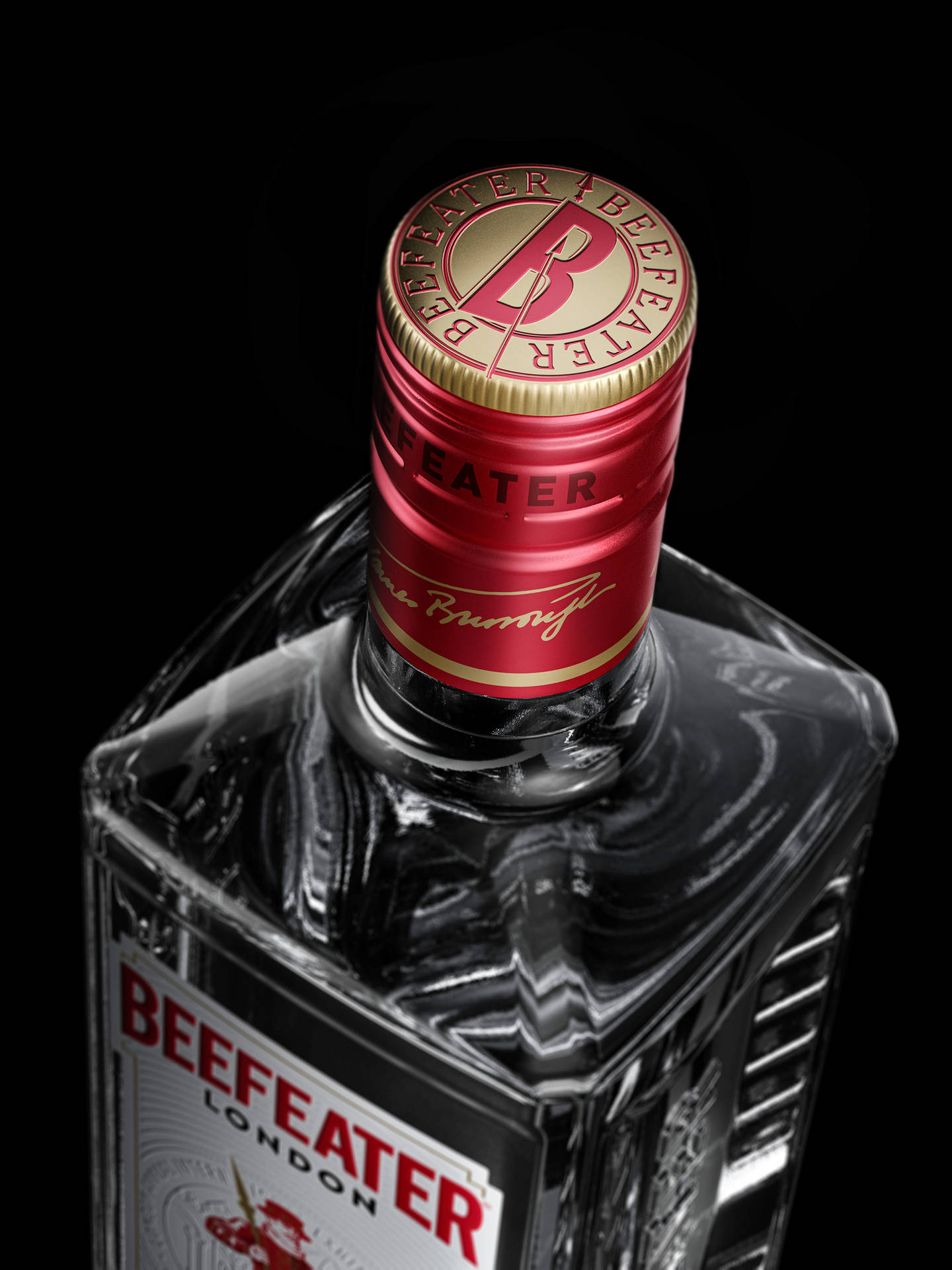 Beefeater 氈酒瓶，紅色金色瓶蓋，黑色背景