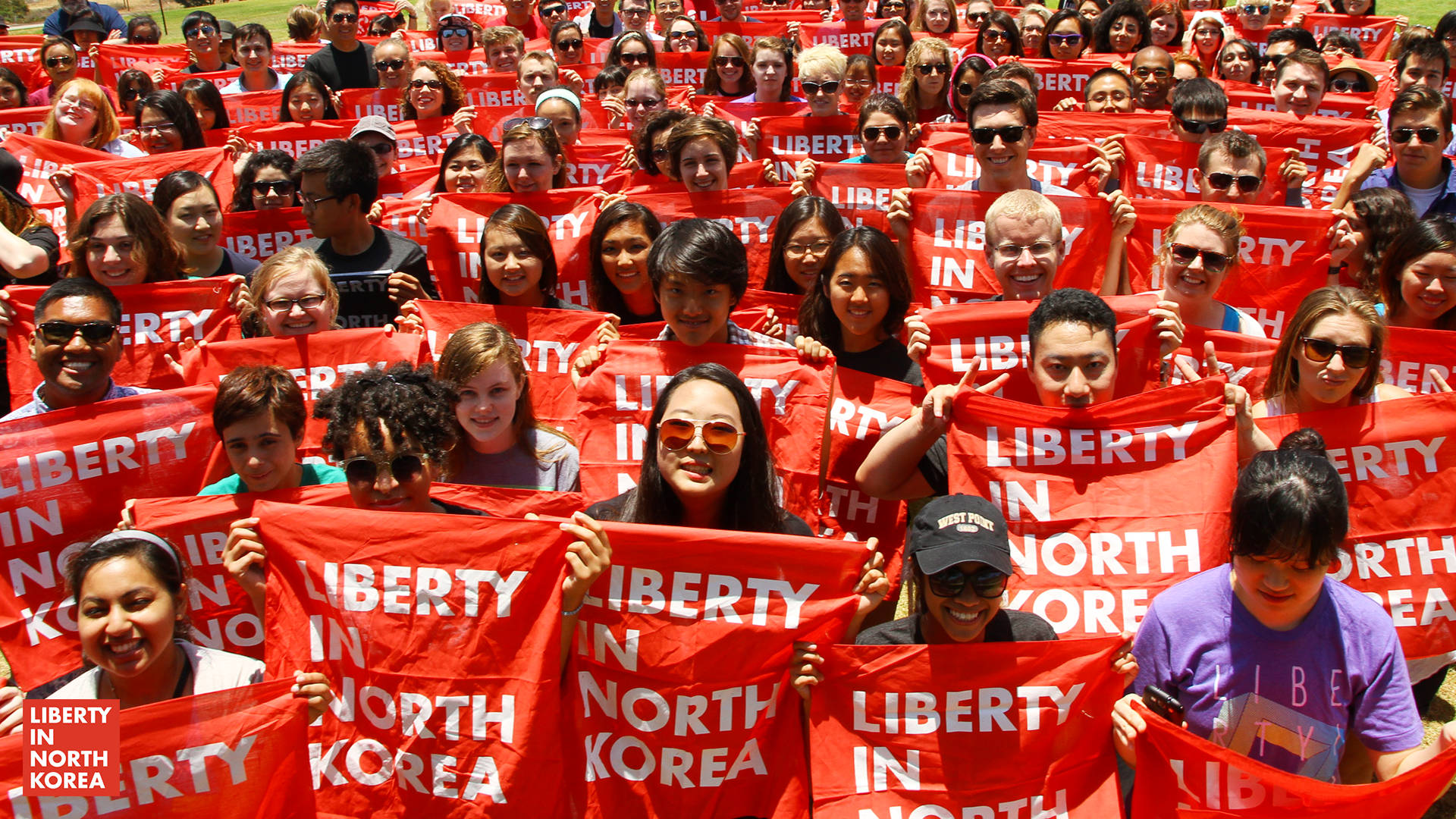 抗議活動中高舉紅色「Liberty in North Korea」橫幅的人群。