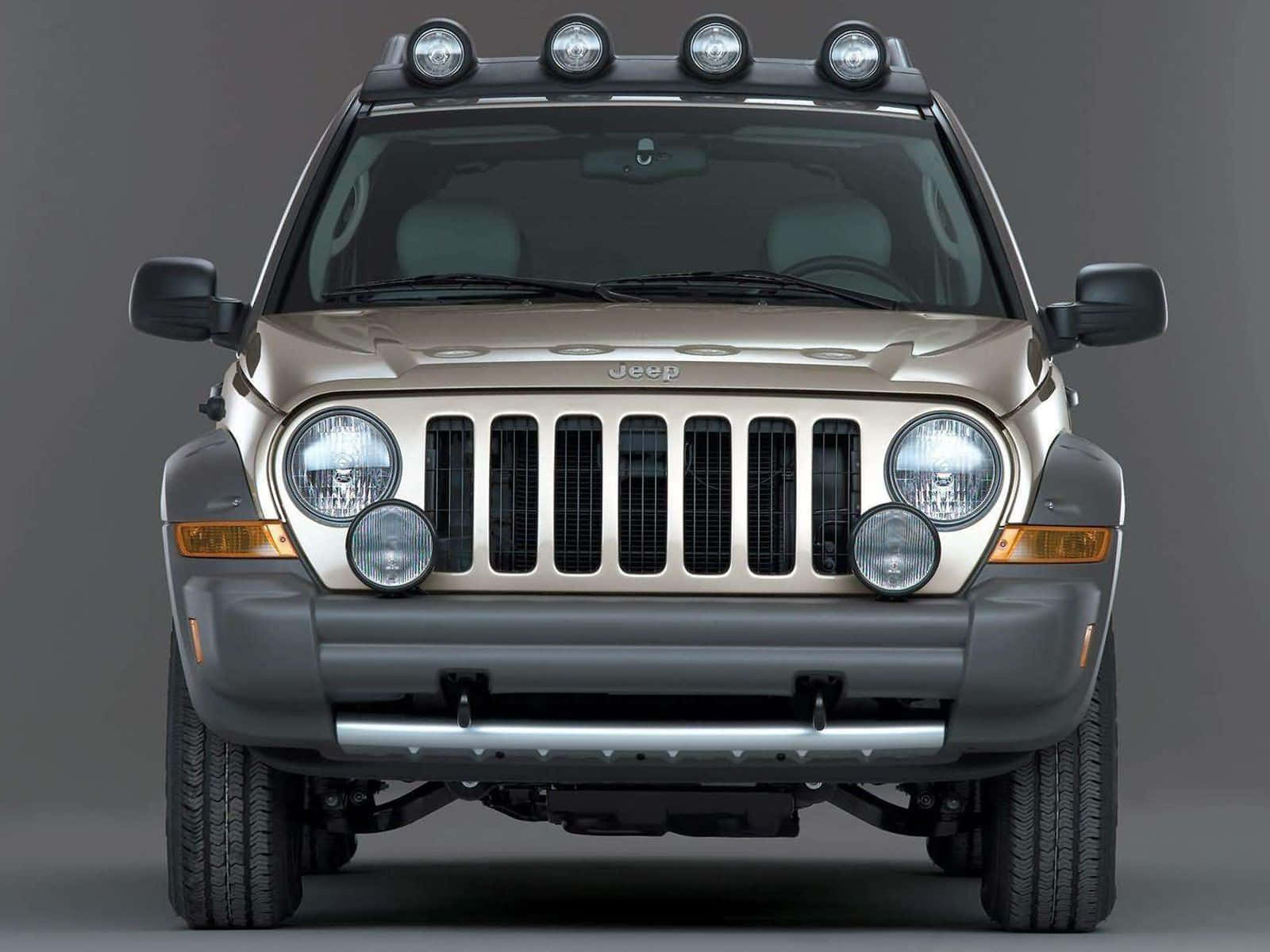 Jeep Liberty 桌布 壁紙 — 米色Jeep Wrangler正面視圖，配備車頂射燈和鍍鉻格柵，背景為灰色工作室。