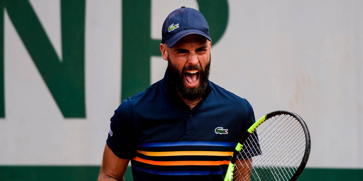 Benoit Paire 比賽中擊球 壁紙 — 一位留鬍鬚的網球選手，戴著藍色帽子，穿著條紋衫，在紅土場上握緊球拍，發出勝利的吼叫。