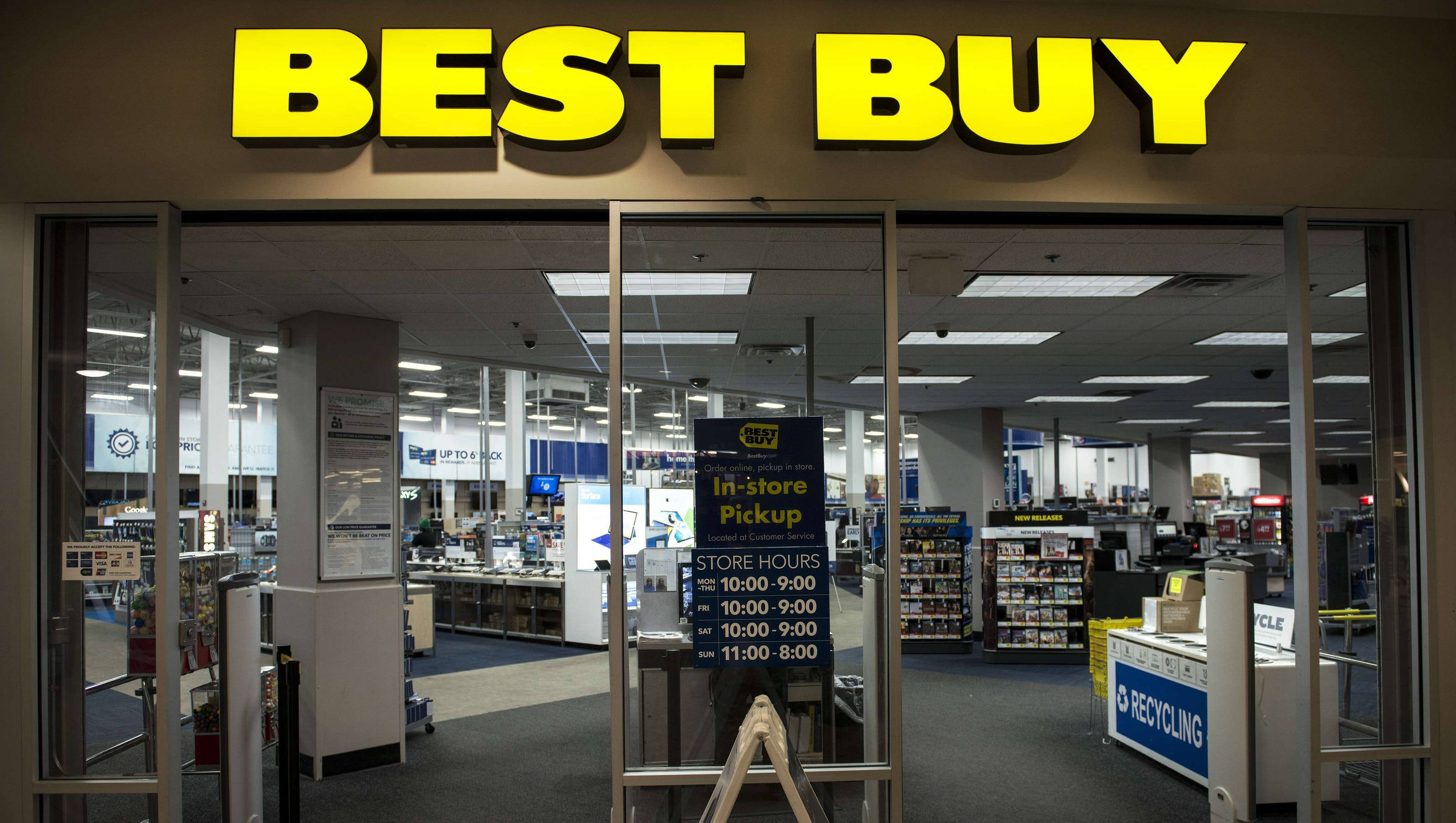 Best Buy店面 壁紙 — 光線充足的Best Buy商店入口，玻璃門和黃色標誌揭示內部的電子產品通道。