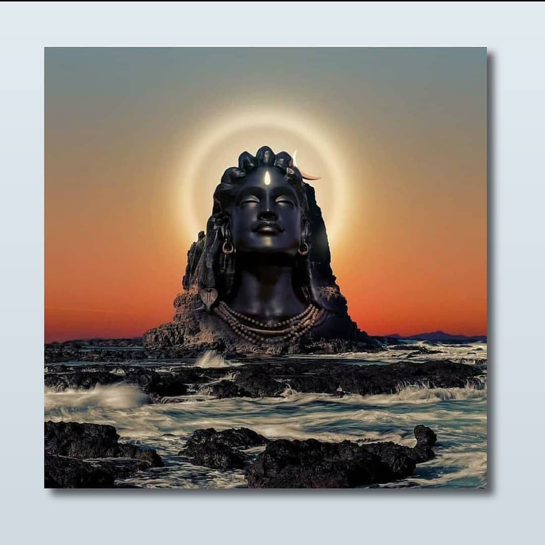 帶有光暈的黑色石頭濕婆雕像在日落時從海洋中升起