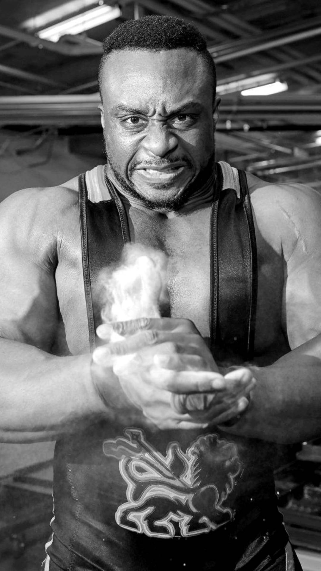 Big E 黑白風格摔角手 壁紙 — 一張黑白肖像，描繪一位肌肉發達的摔角手在健身房中用力將粉筆在雙手間研磨。