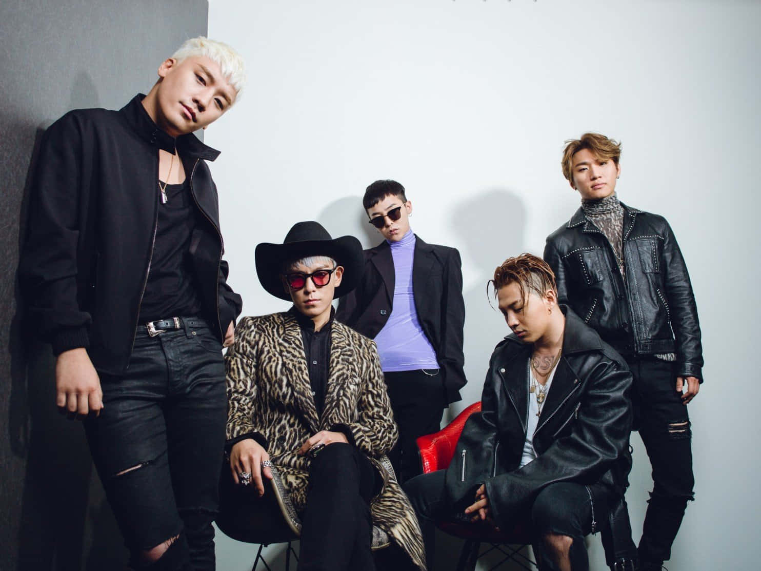 BIGBANG 四位成員：G-Dragon、T.O.P.、太阳與大聲 壁紙 — 五位時尚男士穿著前衛服裝，在戲劇性燈光下自信地靠著素牆擺姿勢。