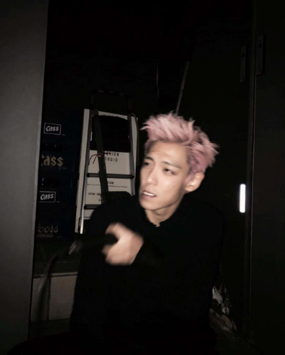 「Bigbang：韓國流行音樂先驅」 壁紙 — 一個喺黑暗房間入面、喺自動販賣機附近揸住咪高峰嘅人，有尖尖嘅粉紅色頭髮。