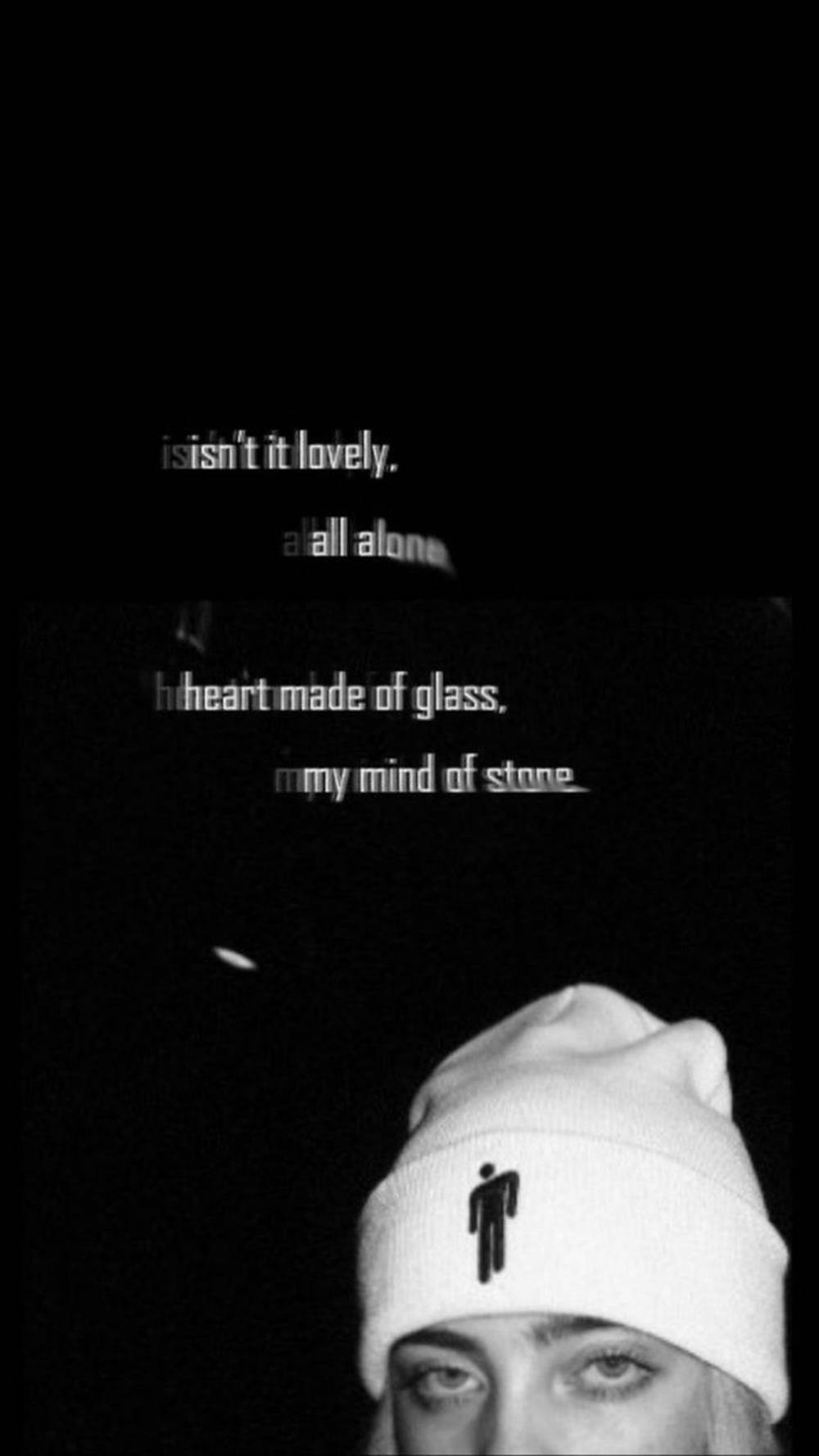 Billie Eilish《Lovely》可愛帽飾美學壁紙 壁紙 — 一個黑白特寫，一個人戴著帶有黑色標誌的白色無邊帽，背景為深色，帶有模糊的文字疊加。